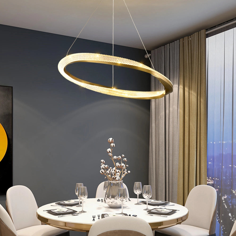 Modern LED chandelier with a golden minimalist pendant light design hanging above a stylish dining table set, featuring wooden chairs and contemporary interior decor.