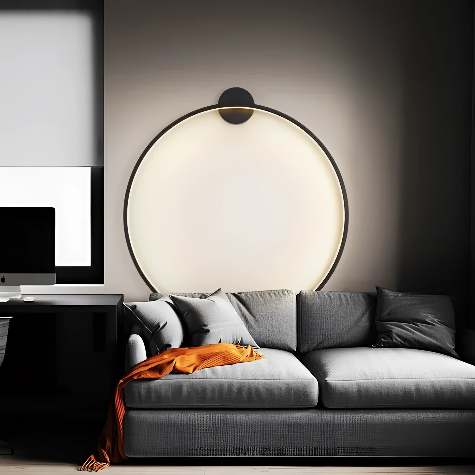 Modern LED circle wall lamp illuminating a luxury bedroom interior, featuring a comfortable black couch, wooden table, and stylish decor.