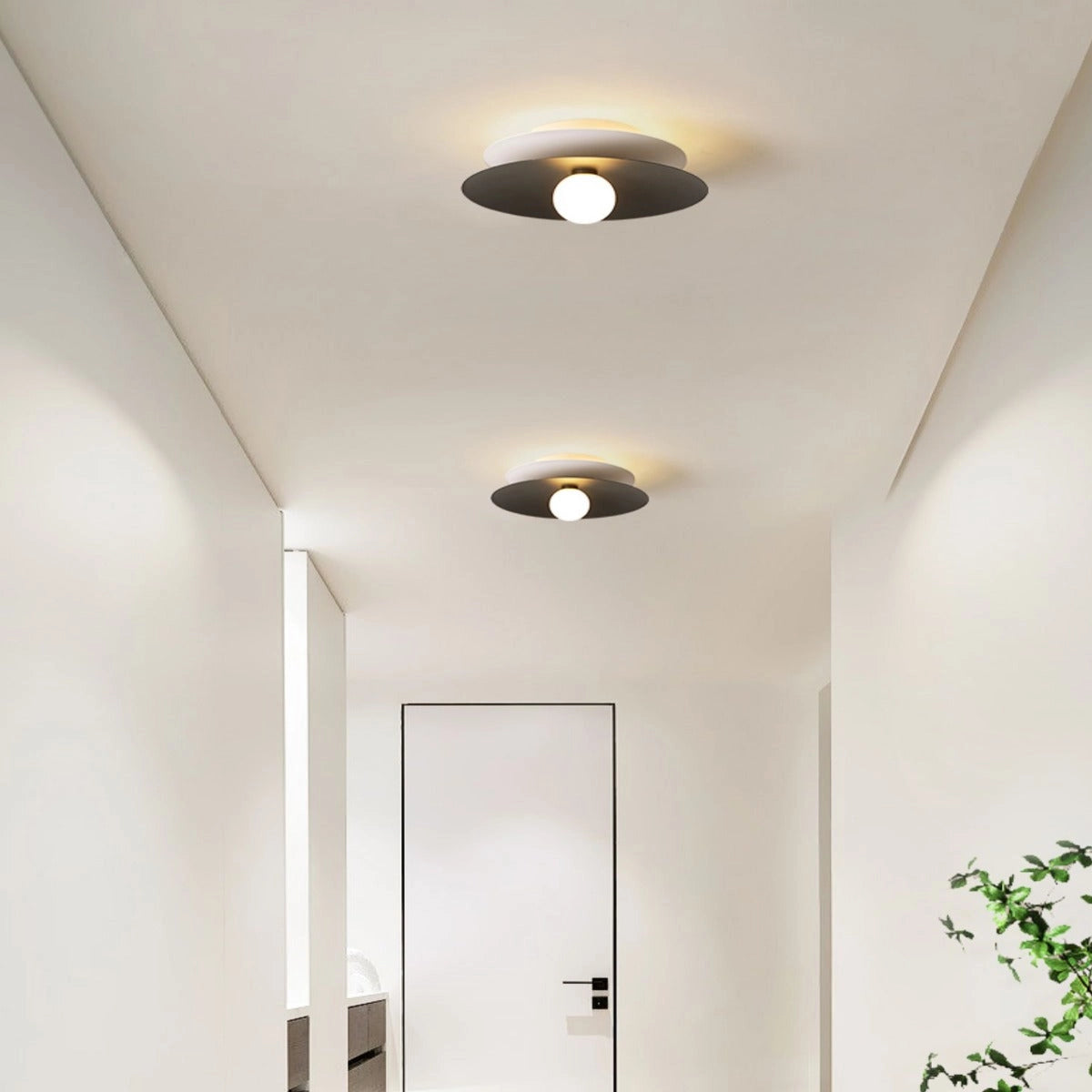 Modern black LED disc ceiling light with a minimalist design, flush mounted to a wooden ceiling, emitting warm white light in a contemporary interior setting.