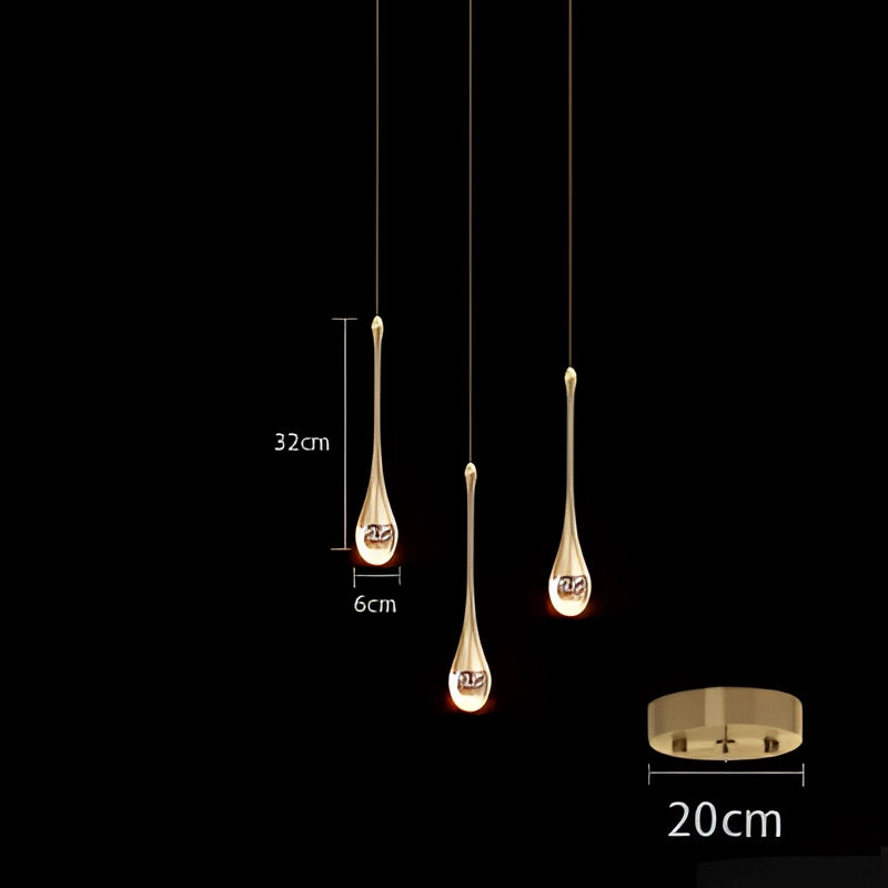 Modern LED gold teardrop pendant lights with three heads, emitting a warm white glow, hanging from the ceiling in a kitchen or dining room setting.