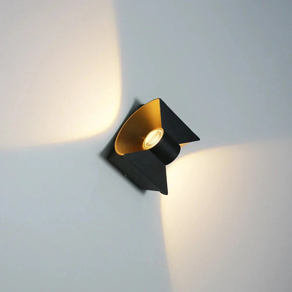 Modern LED wall sconce featuring a black and gold geometric design with metallic accents and a triangular shape, ideal for adding a stylish artistic touch to any space.