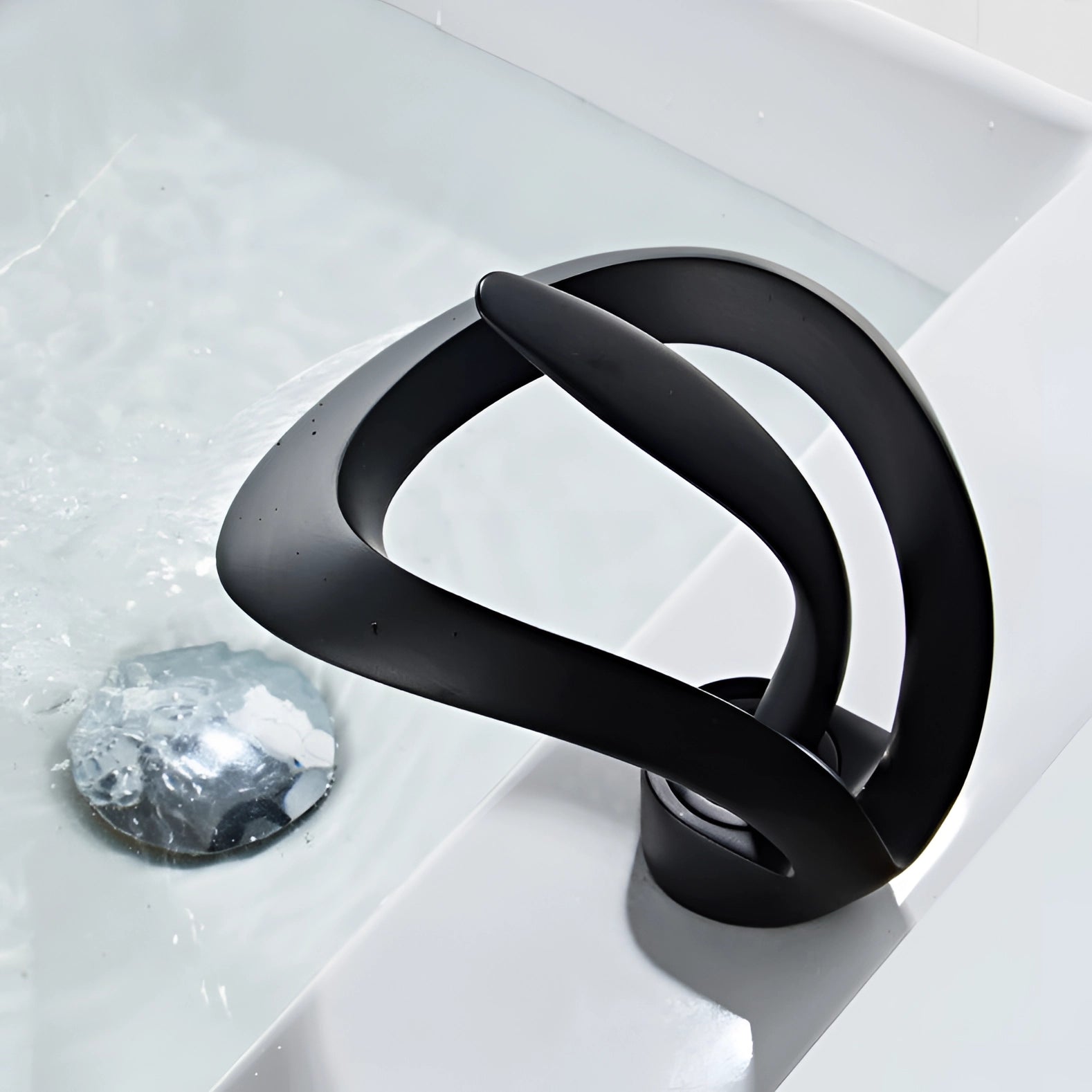 Sleek matte black waterfall faucet with a modern design, featuring a streamlined spout that elegantly cascades water in a luxurious bathroom setting.