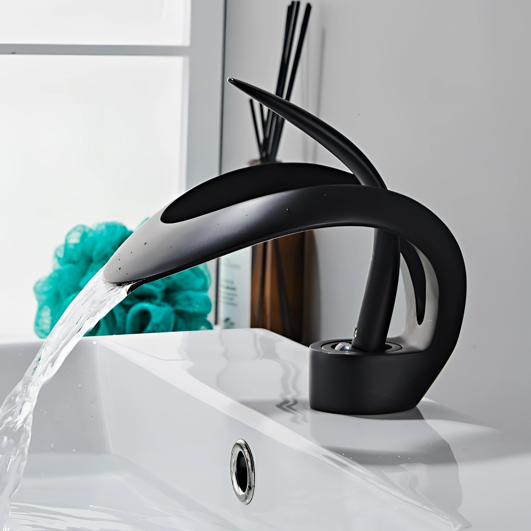 Modern matte black waterfall faucet with a sleek, futuristic design, installed over a sink, showcasing its elegant plumbing fixture and refined material properties.