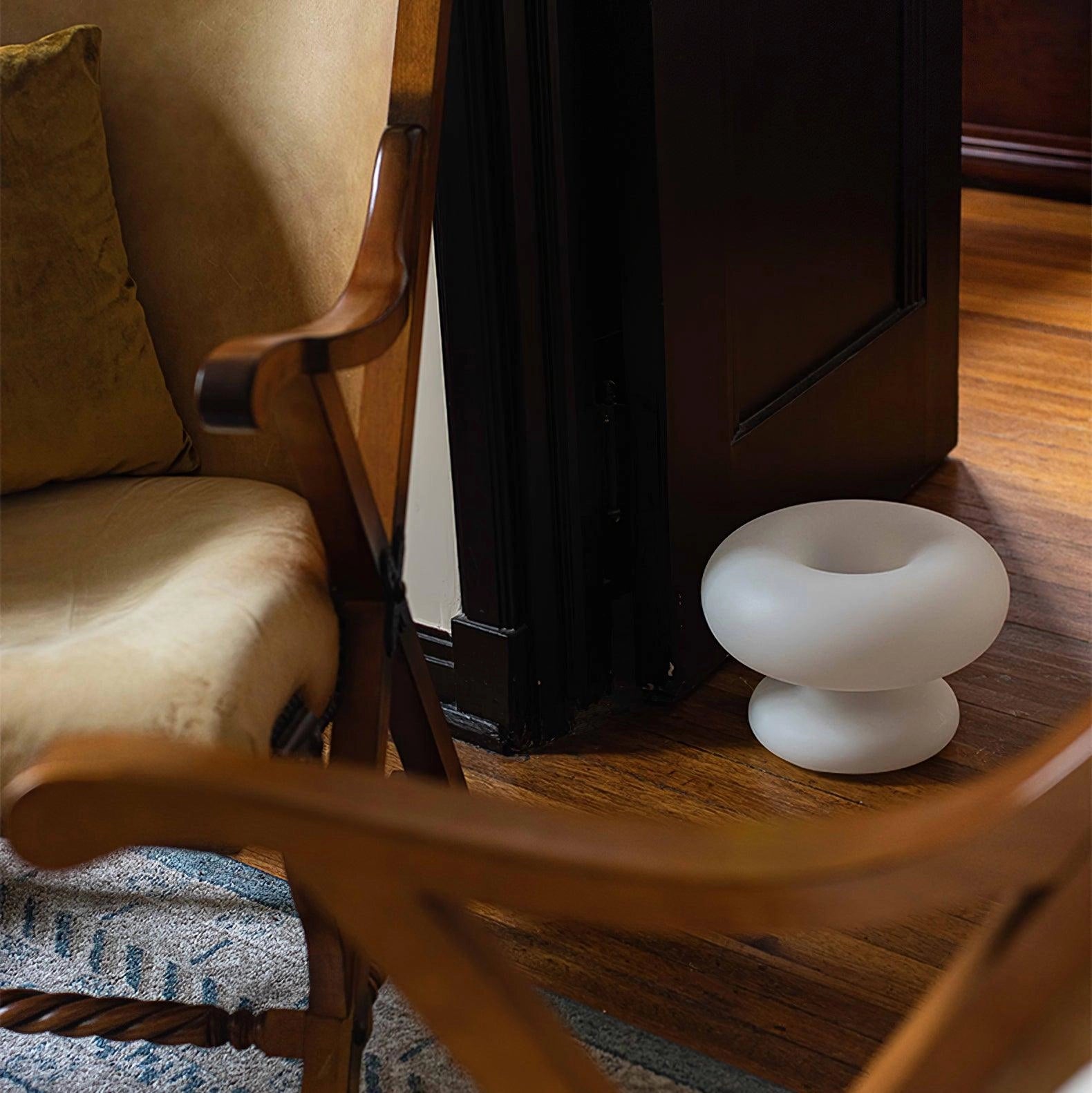 Modern Mushroom Table Lamp on a wooden surface, surrounded by minimalist interior design elements like chairs and hardwood flooring.