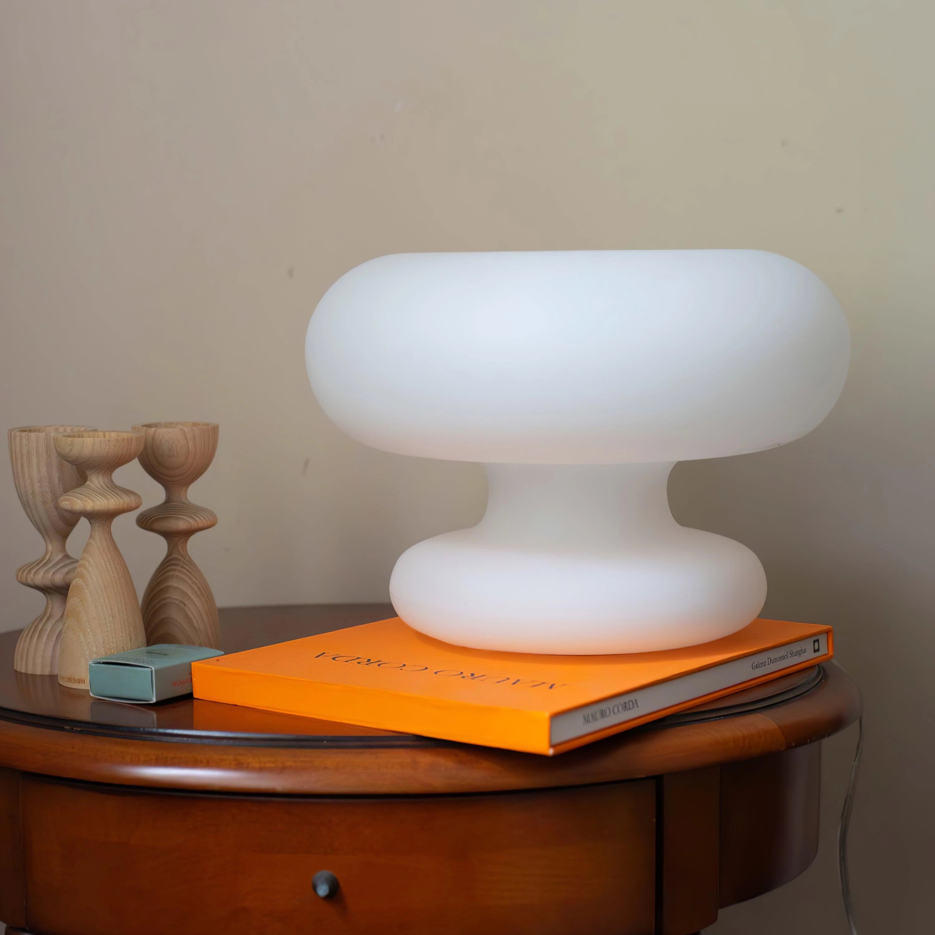 Modern Mushroom Table Lamp on a wooden desk with a minimalist design, surrounded by a wooden chair and shelving unit.