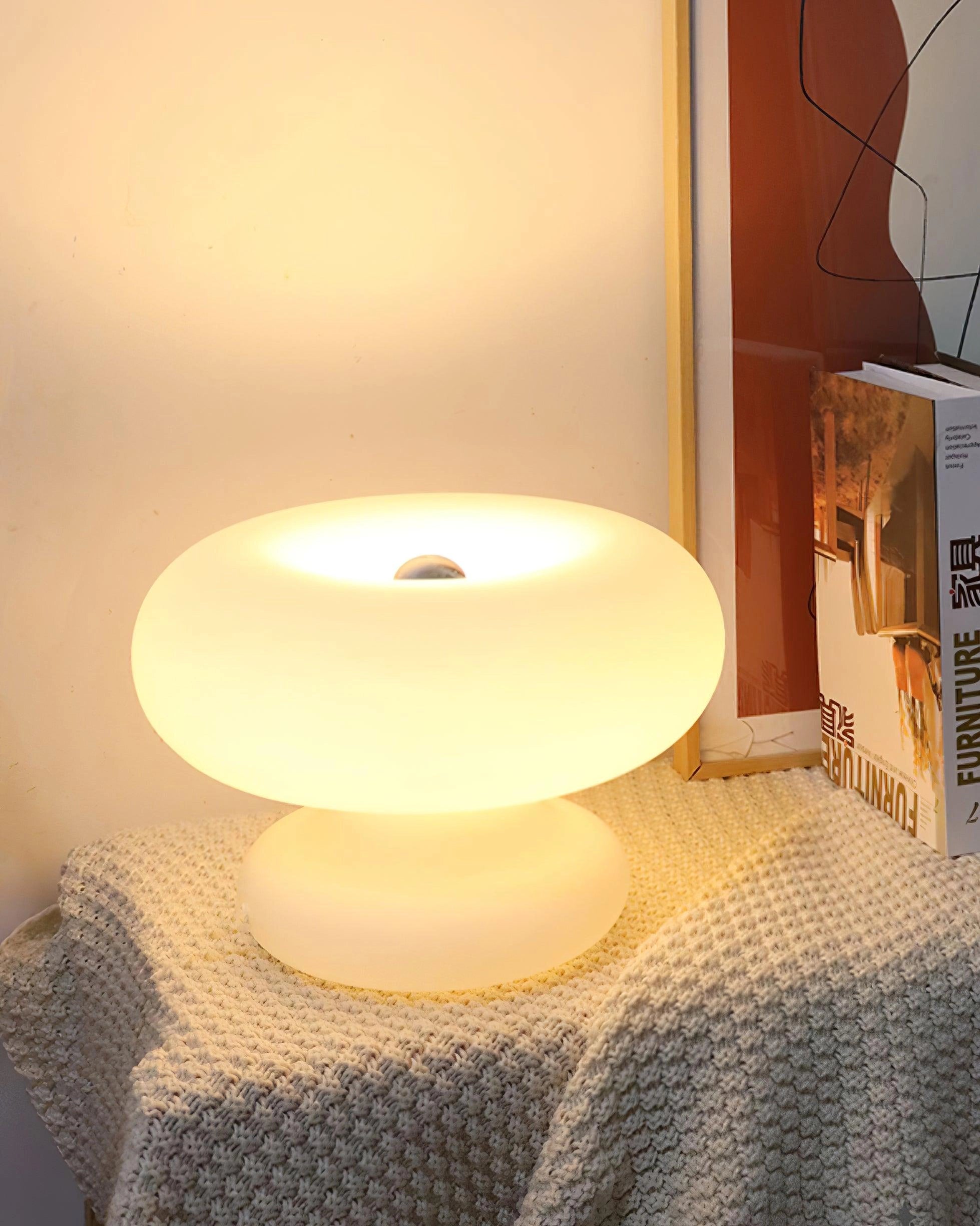 Minimalist mushroom-shaped table lamp with wooden base and white shade, suitable for bedside or living room use, providing comfortable lighting on a modern table.