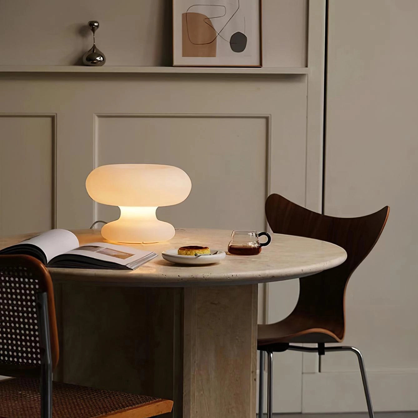 Modern Mushroom Table Lamp placed on a wooden table in a minimalist room with furniture and picture frames in the background.