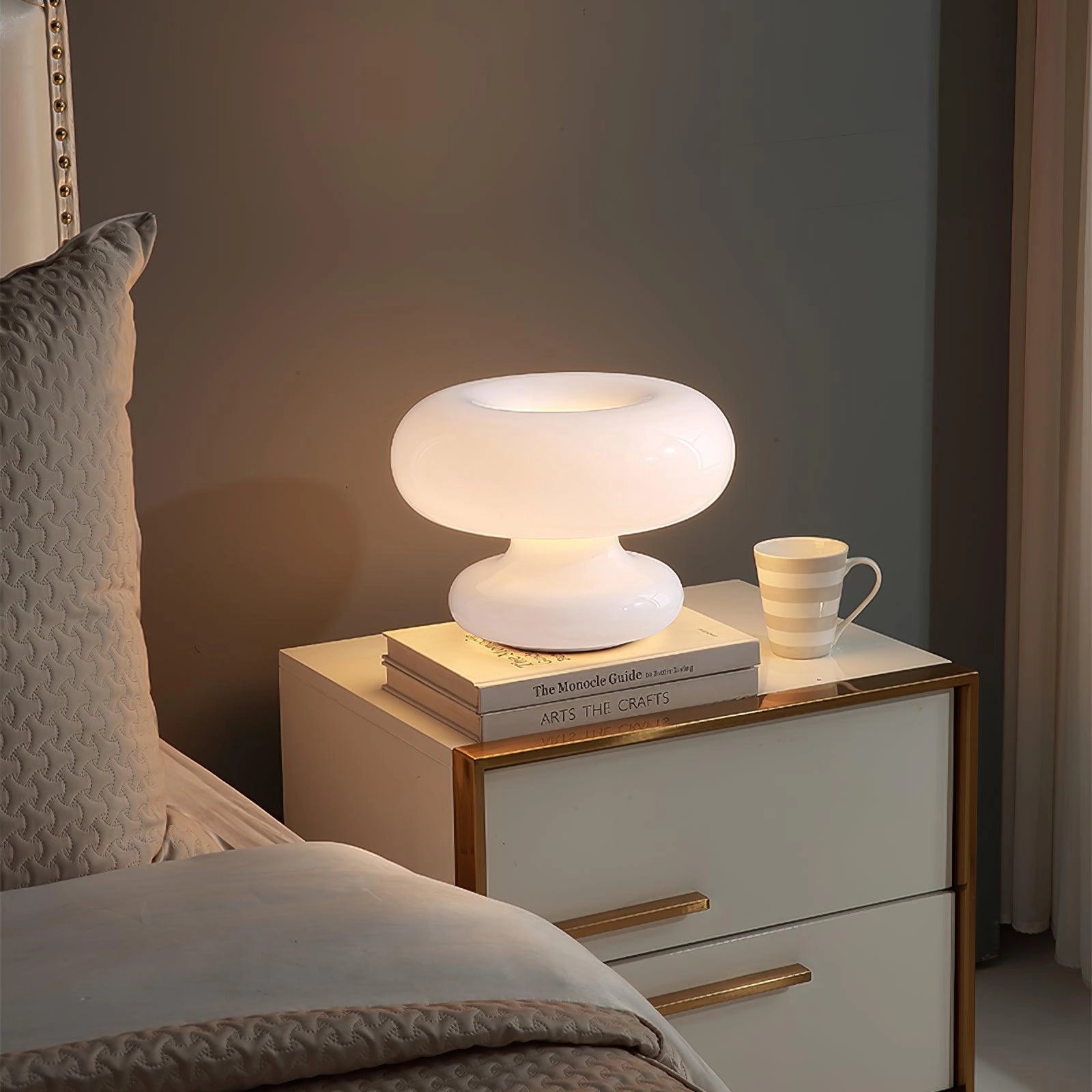 Modern Mushroom Table Lamp with a minimalist design, placed on a wooden bedside table with a beige drawer in a stylishly designed interior room.