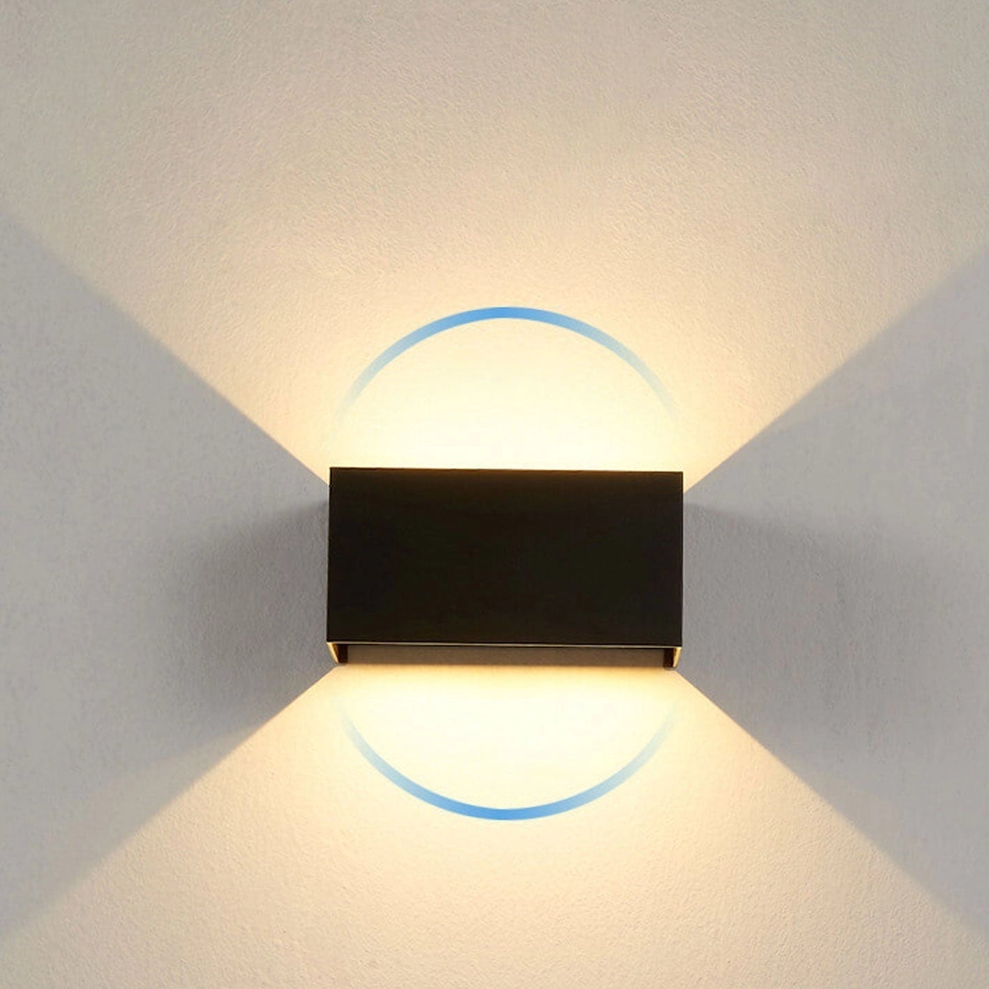 Modern black rectangular LED outdoor wall light mounted on a wall, showcasing its sleek design and weather-resistant features against a clear sky backdrop.