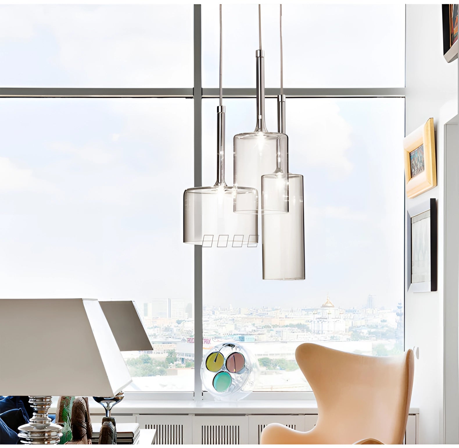 Modern Scandinavian glass pendant lights hanging from a ceiling, complementing a stylish living room setting with wood accents and urban design elements.