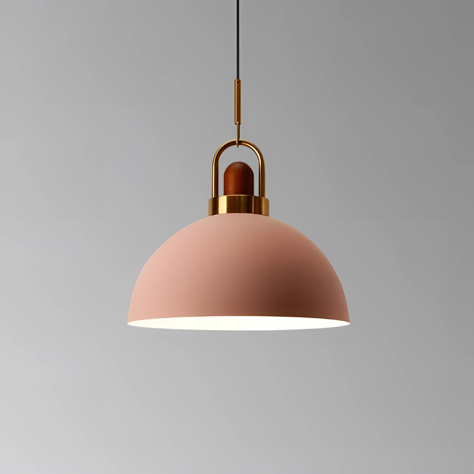 Modern Scandinavian matte pendant light in pink with copper accents, featuring a cone-shaped design hanging from the ceiling. The light fixture combines metal and wood elements, adding an artistic and contemporary touch to the space.