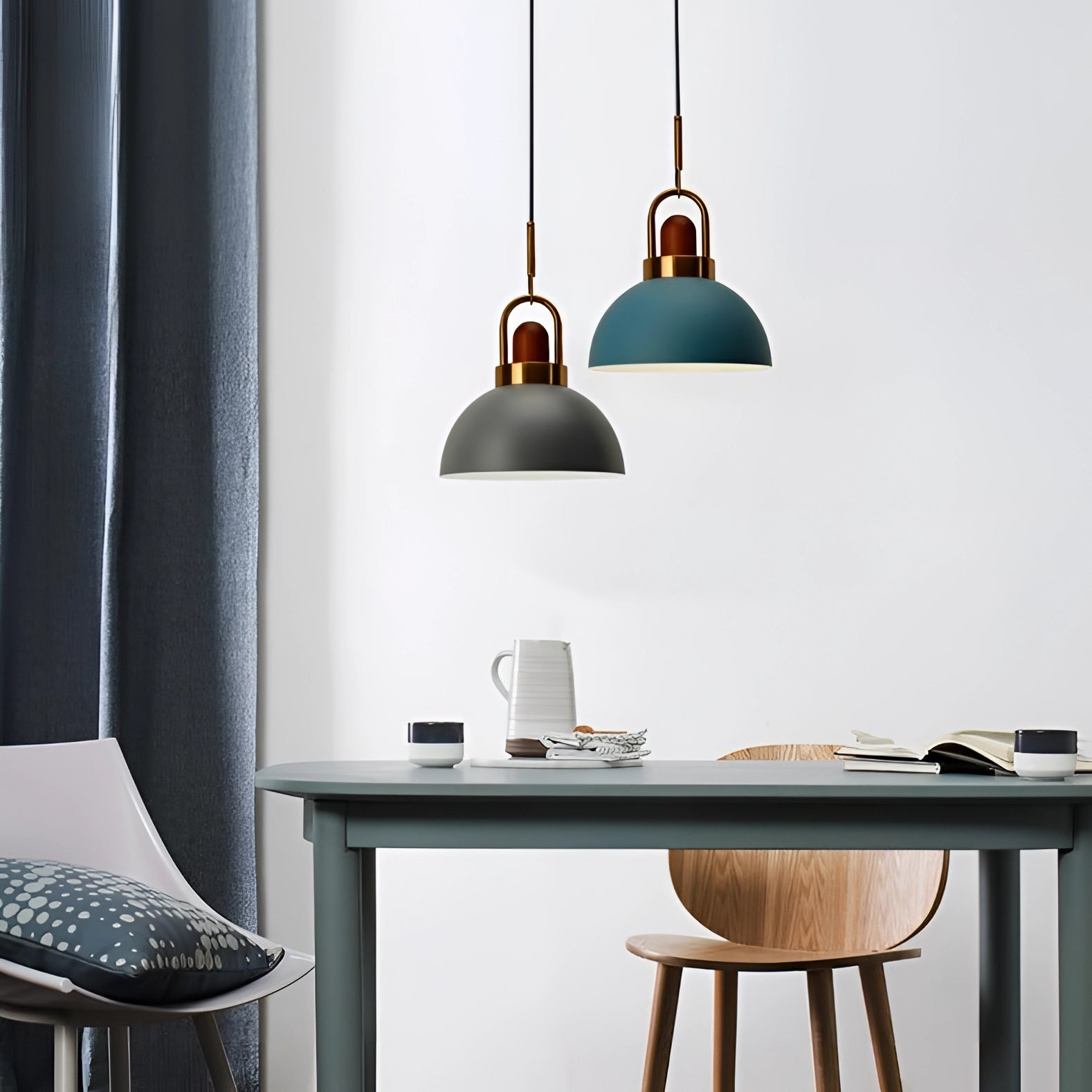 Modern Scandinavian matte pendant light with copper accents hanging above a wooden table, complementing the contemporary interior design with grey and wooden elements.