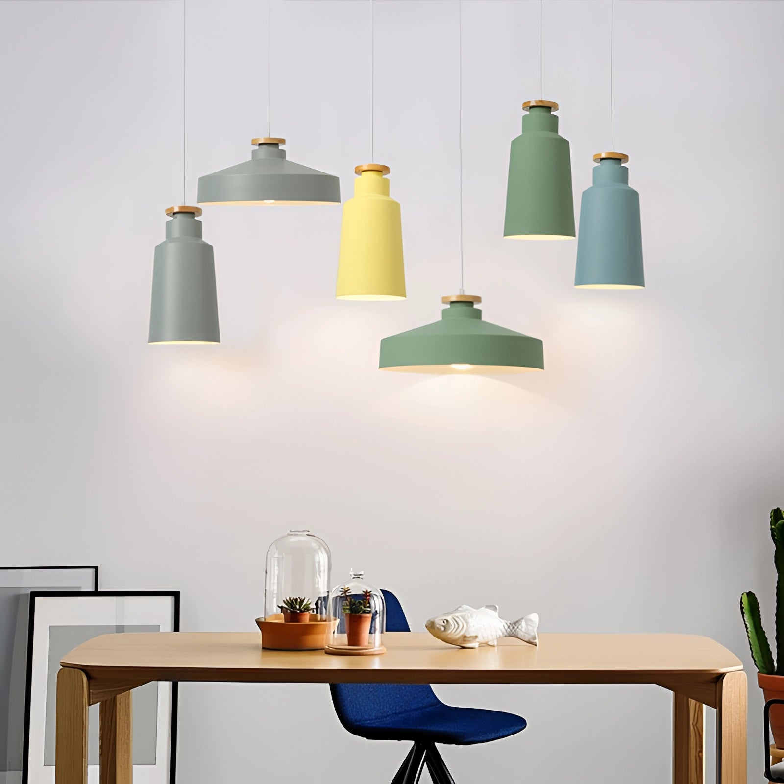 Modern Scandinavian pendant lights in a colorful, adjustable design illuminating a contemporary interior space with wooden furniture and shelving.