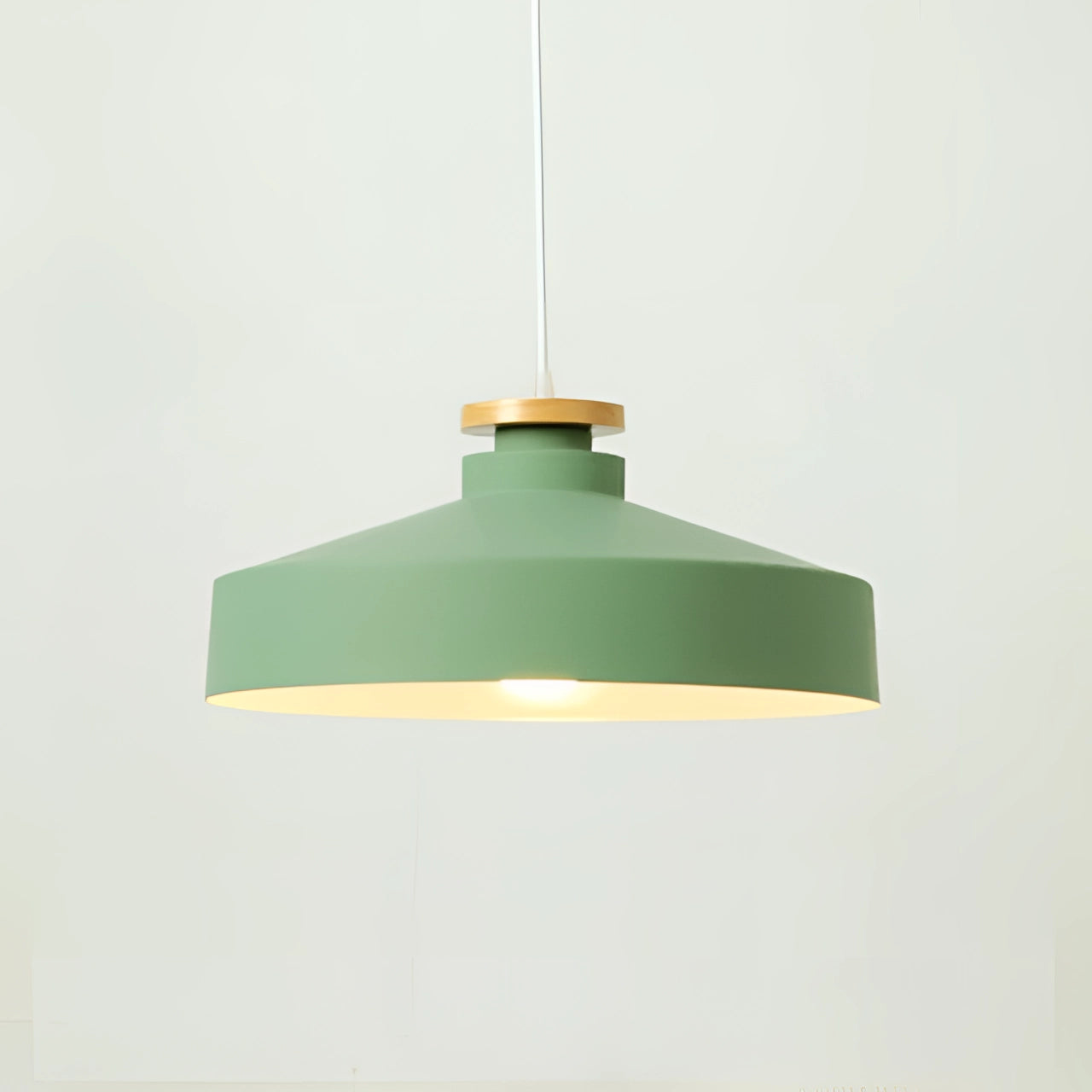 Green modern Scandinavian pendant light with a disk-shaped design featuring a green lampshade and wooden accents, hung from the ceiling.