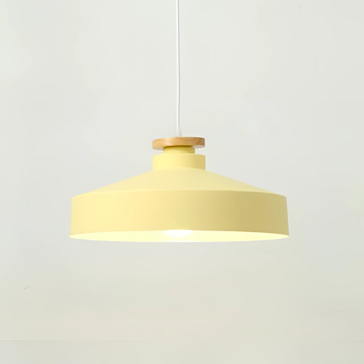 Modern Scandinavian Pendant Light with a yellow disk-shaped design, featuring adjustable height, and a sleek metal and wood combination, hanging from the ceiling.