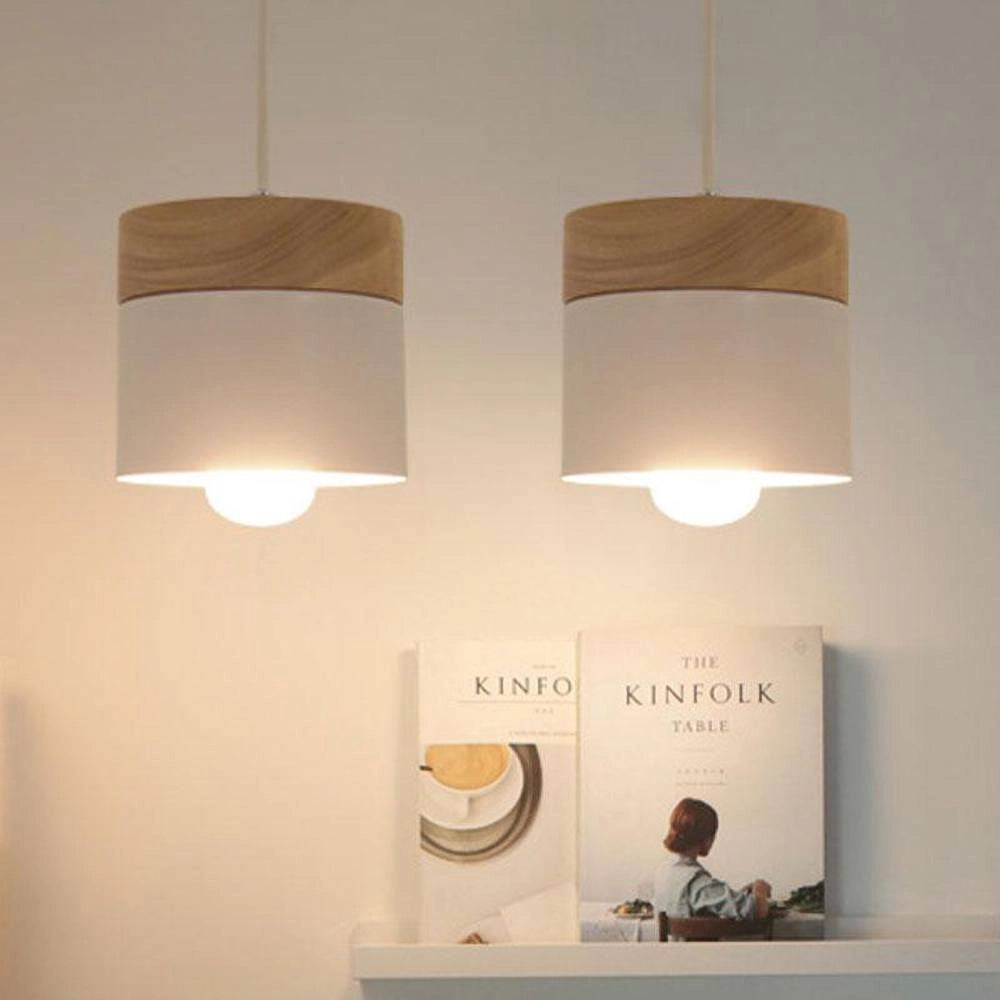 Modern Scandinavian wooden pendant lights in various colors hanging from the ceiling, showcasing minimalist and eco-friendly design.