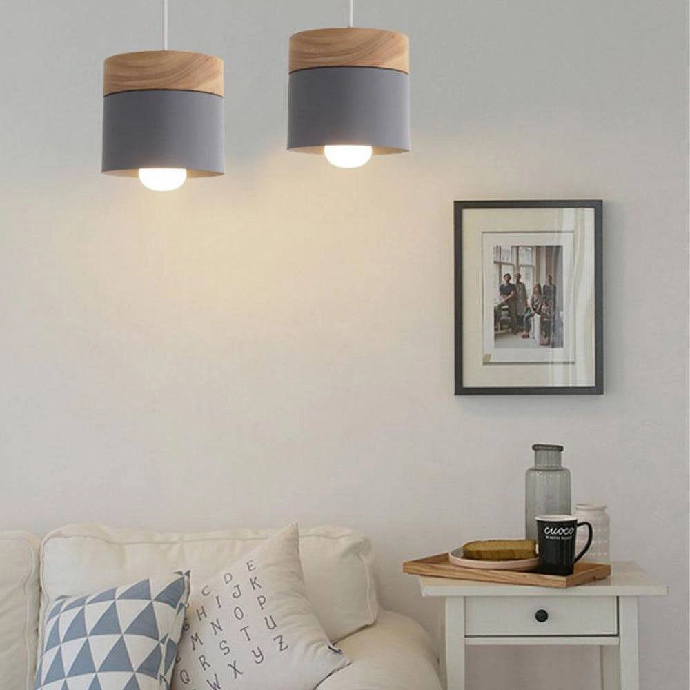 Modern Scandinavian wooden pendant lights hanging from the ceiling in a minimalist, eco-friendly interior design with white and grey accents.