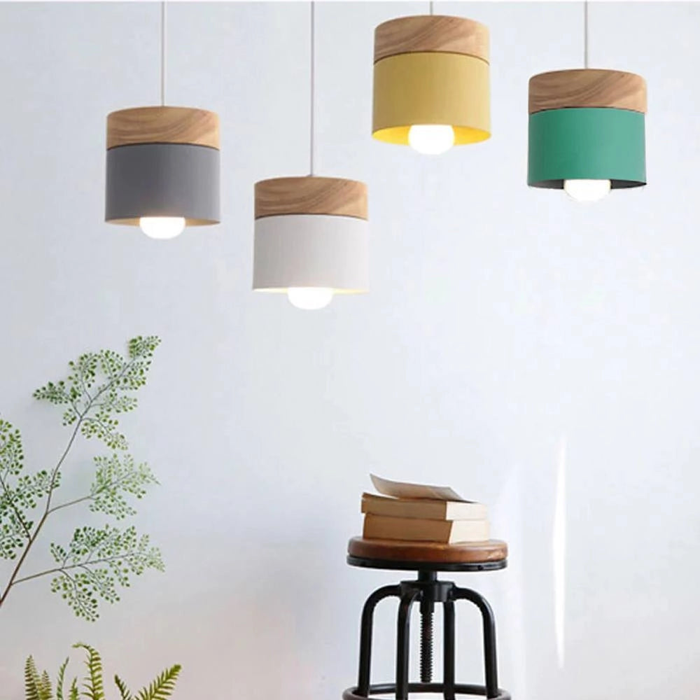 Modern Scandinavian wooden pendant lights in green, white, and yellow, featuring minimalist design and eco-friendly materials, illuminating an interior space.