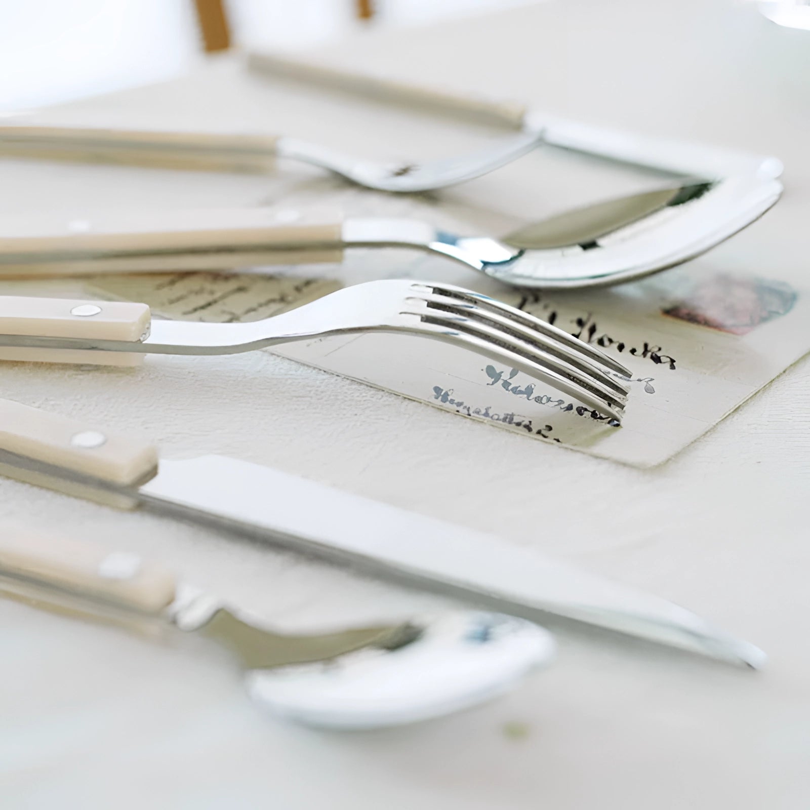 Modern stainless steel cutlery set with 24 pieces featuring sleek black handles displayed on a wooden table, showcasing elegant and stylish tableware suitable for any dining setting.