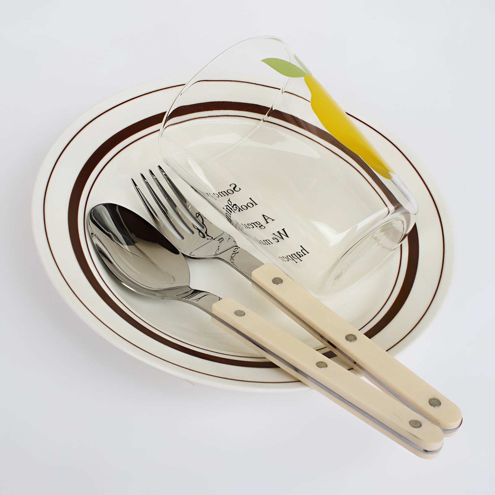 Modern stainless steel cutlery set with a sleek black handle, featuring 24 pieces including forks, knives, and spoons arranged neatly on a wooden surface.