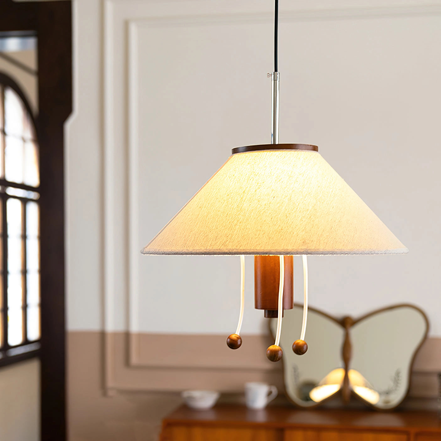 Modern Triangle Pendant Lamp with Wooden Accents hanging in a stylish room with natural light streaming through a window, showcasing adjustable lighting features and a contemporary design.