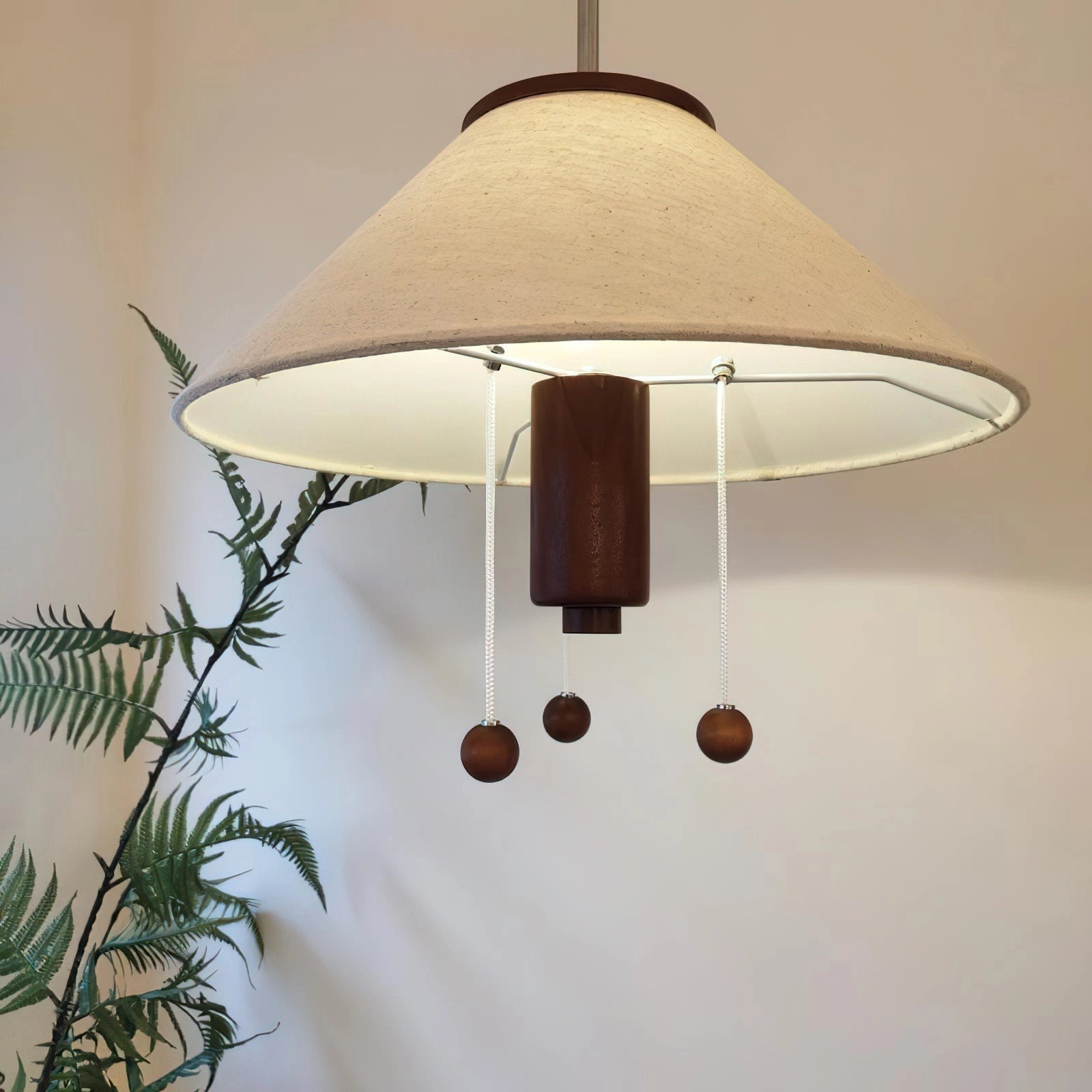 Modern triangle pendant lamp with wooden accents, adjustable lighting, featuring a geometric rectangular shade, hanging from the ceiling, with natural wood materials, and a potted plant in the background.