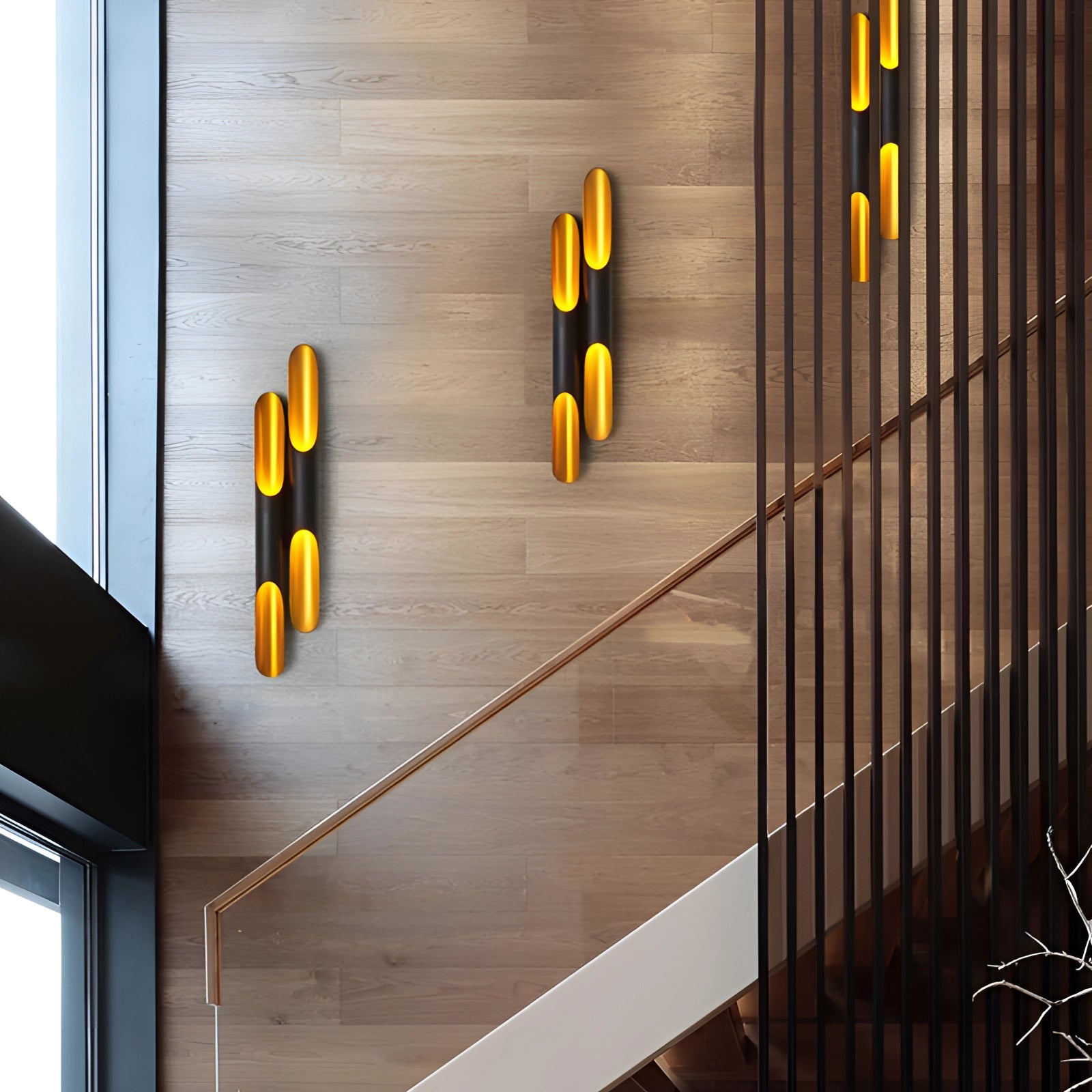 Modern vertical LED wall sconce on an architectural building exterior, featuring minimalist design with wood accents and orange lighting, positioned near a window and stairs, photographed during daytime.