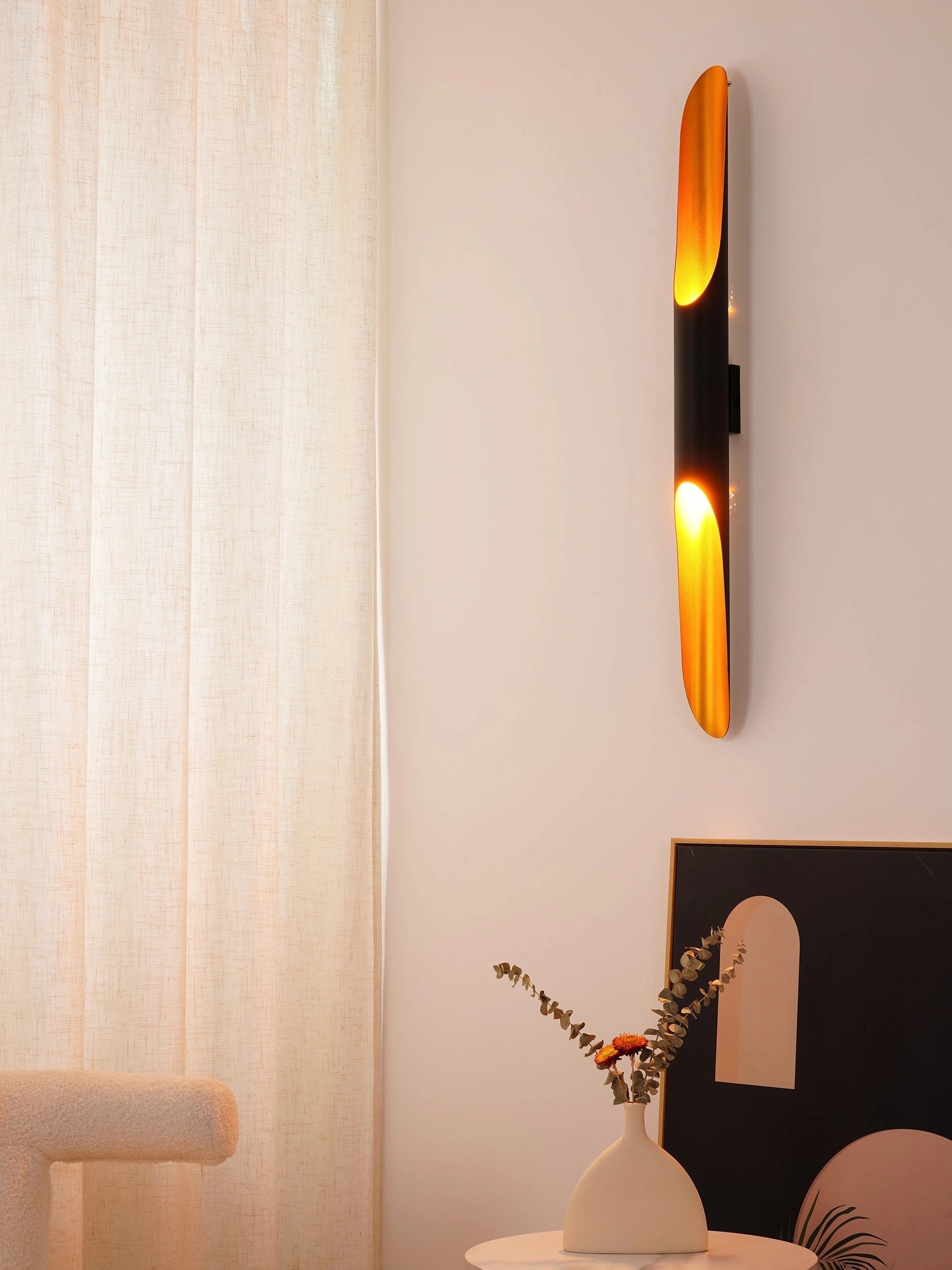 Modern vertical LED wall sconce with a minimalist architectural design, mounted on a textured wooden wall, emitting a warm orange glow that enhances the interior design.