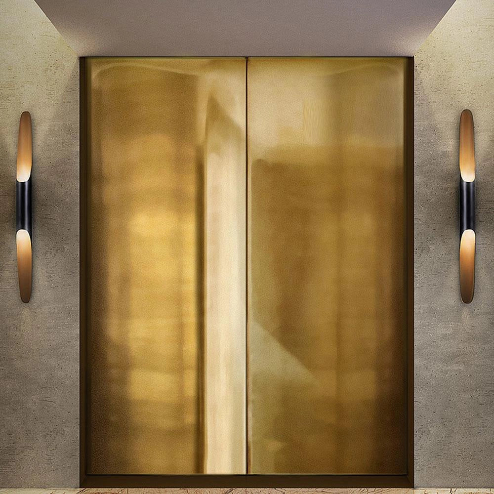 
A modern vertical LED wall sconce featuring a minimalist architectural design with a rectangular shape, accented by gold and wood elements, and incorporating metal and glass materials.