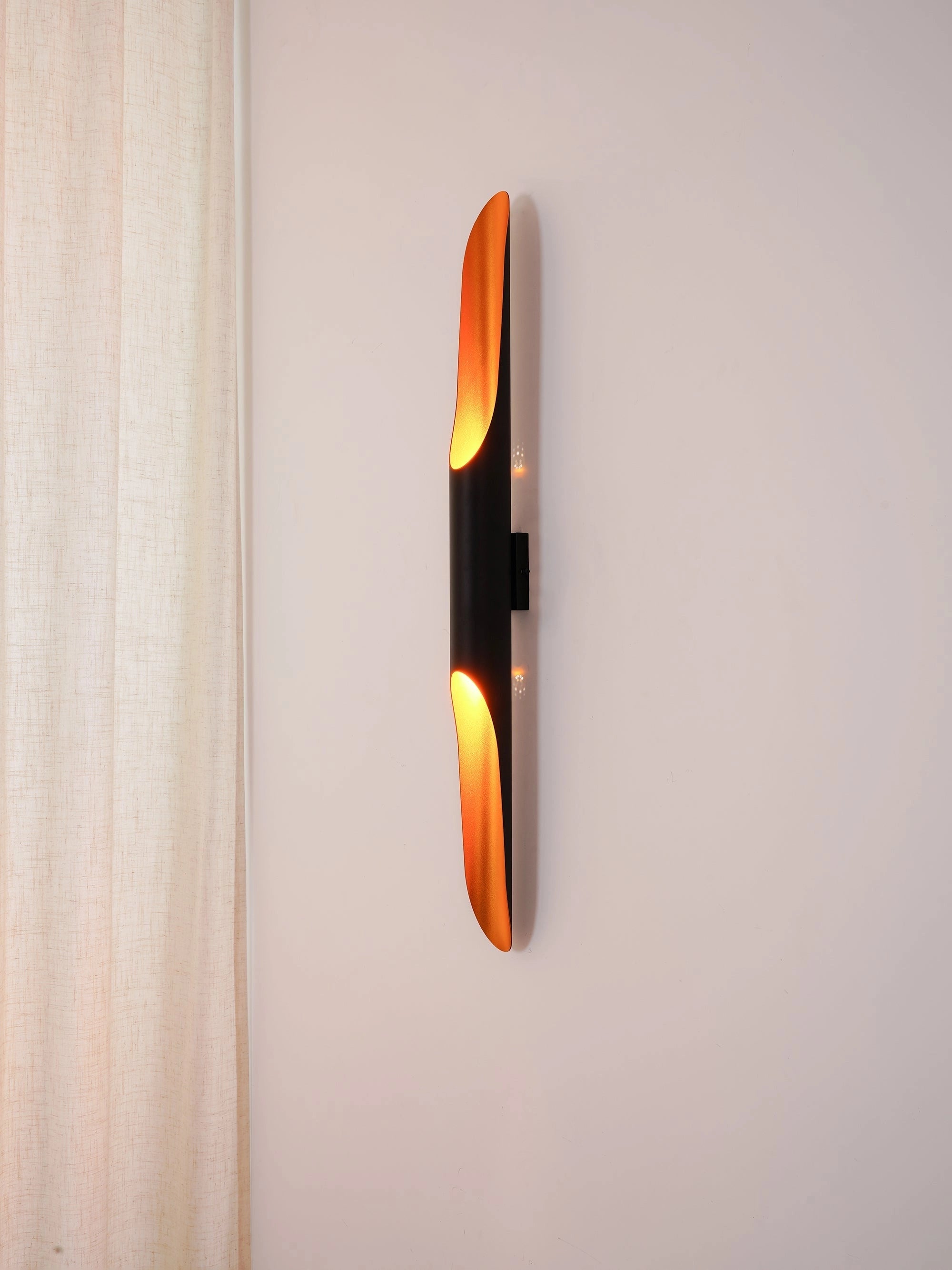 Modern vertical LED wall sconce with minimalist architectural design, featuring a warm amber glow and sleek wood accents.