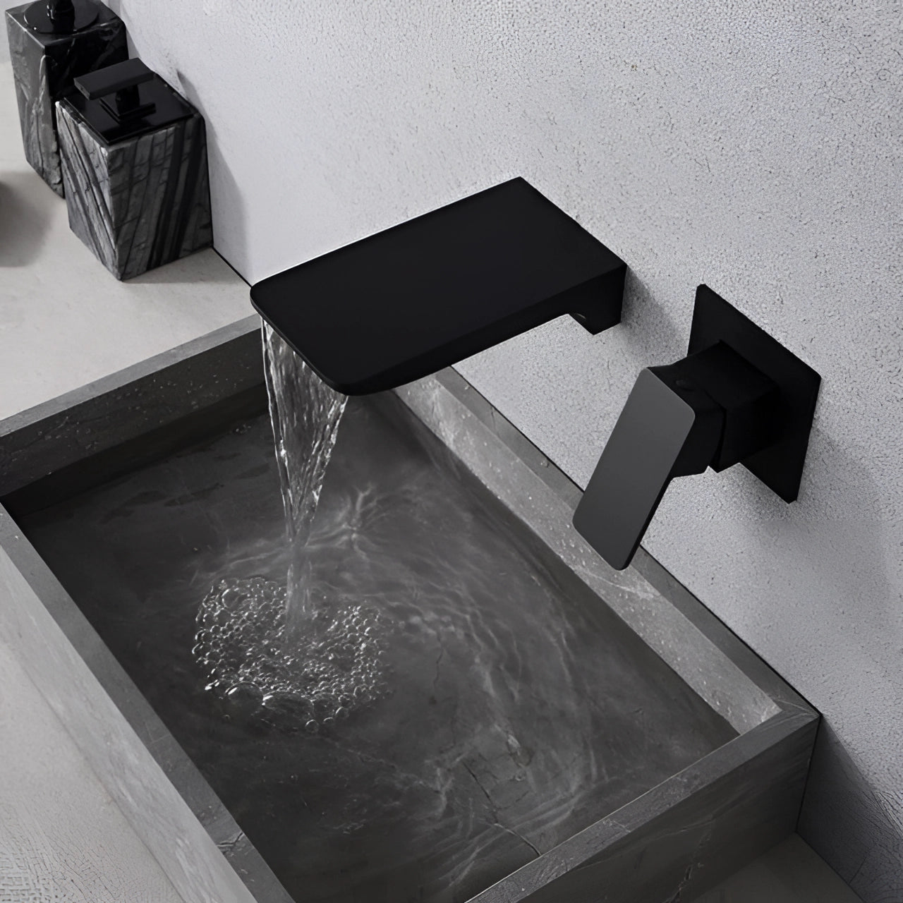 
A modern wall-mounted waterfall faucet with a chrome finish and a sleek square design, installed above a wooden surface.