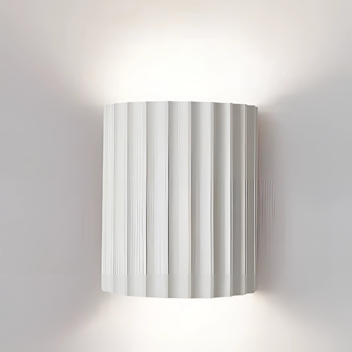 Modern white ribbed wall sconce with a cylindrical design, featuring contemporary indoor lighting suitable for 110 V-120 V electrical systems in USA and Canada; shown mounted on a wall with a mix of composite materials including metal, providing a sleek and stylish appearance.