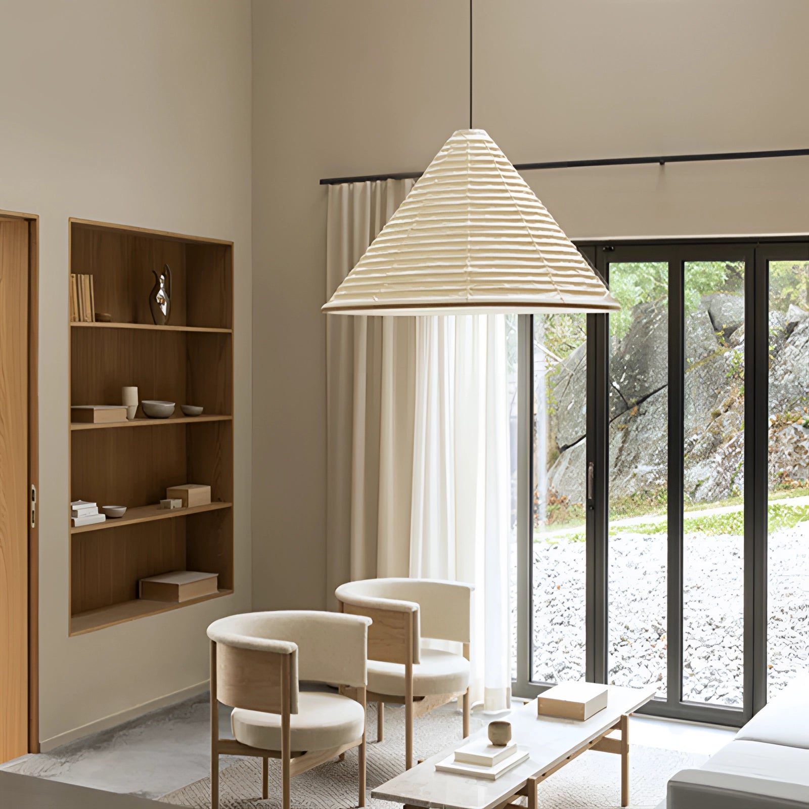 Modern white Scandinavian cone pendant light with minimalist design hanging from the ceiling, illuminating a contemporary interior space with wooden accents and large windows.