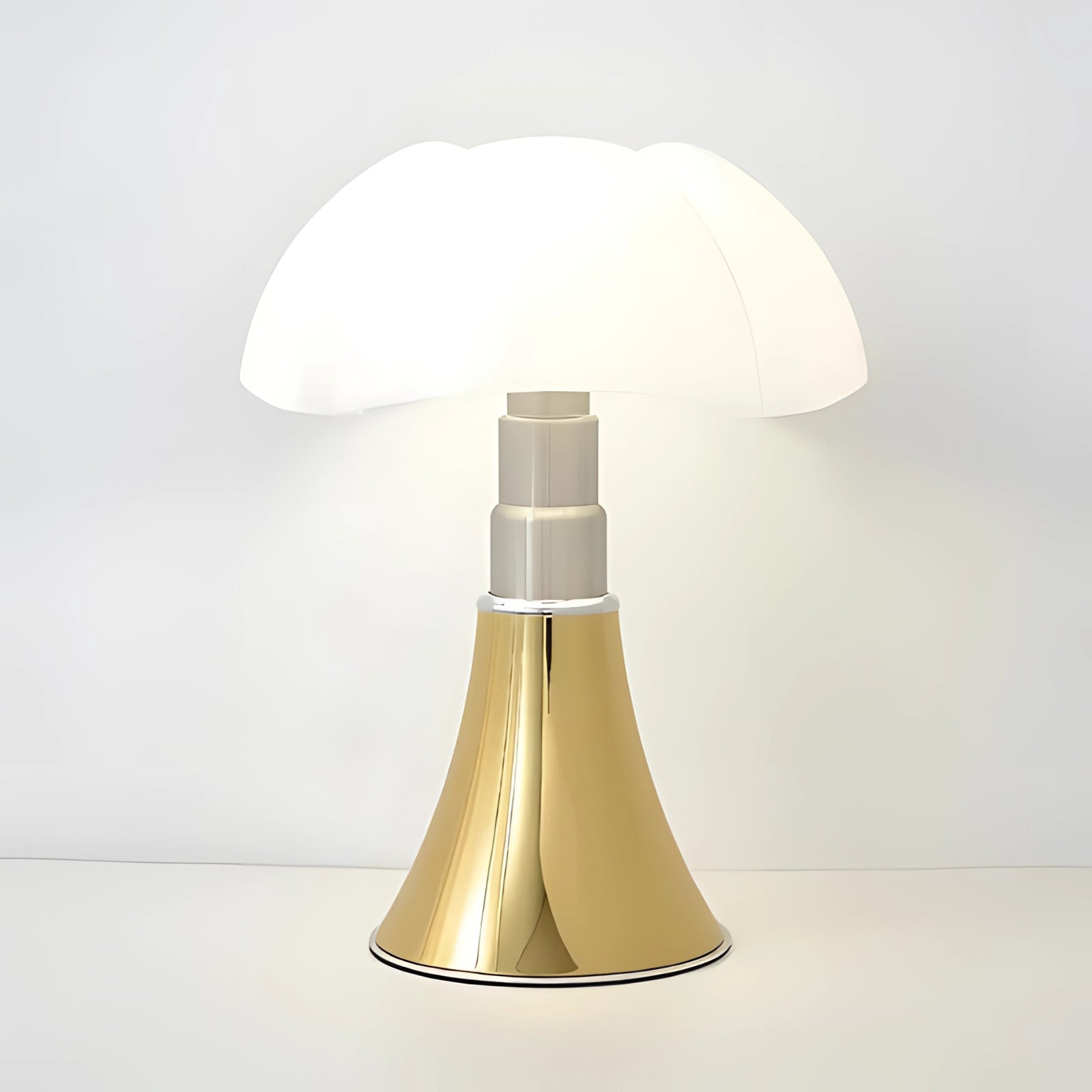 Modern white table lamp with a sleek, minimalist mushroom design featuring a gold accent, set on a wooden table.