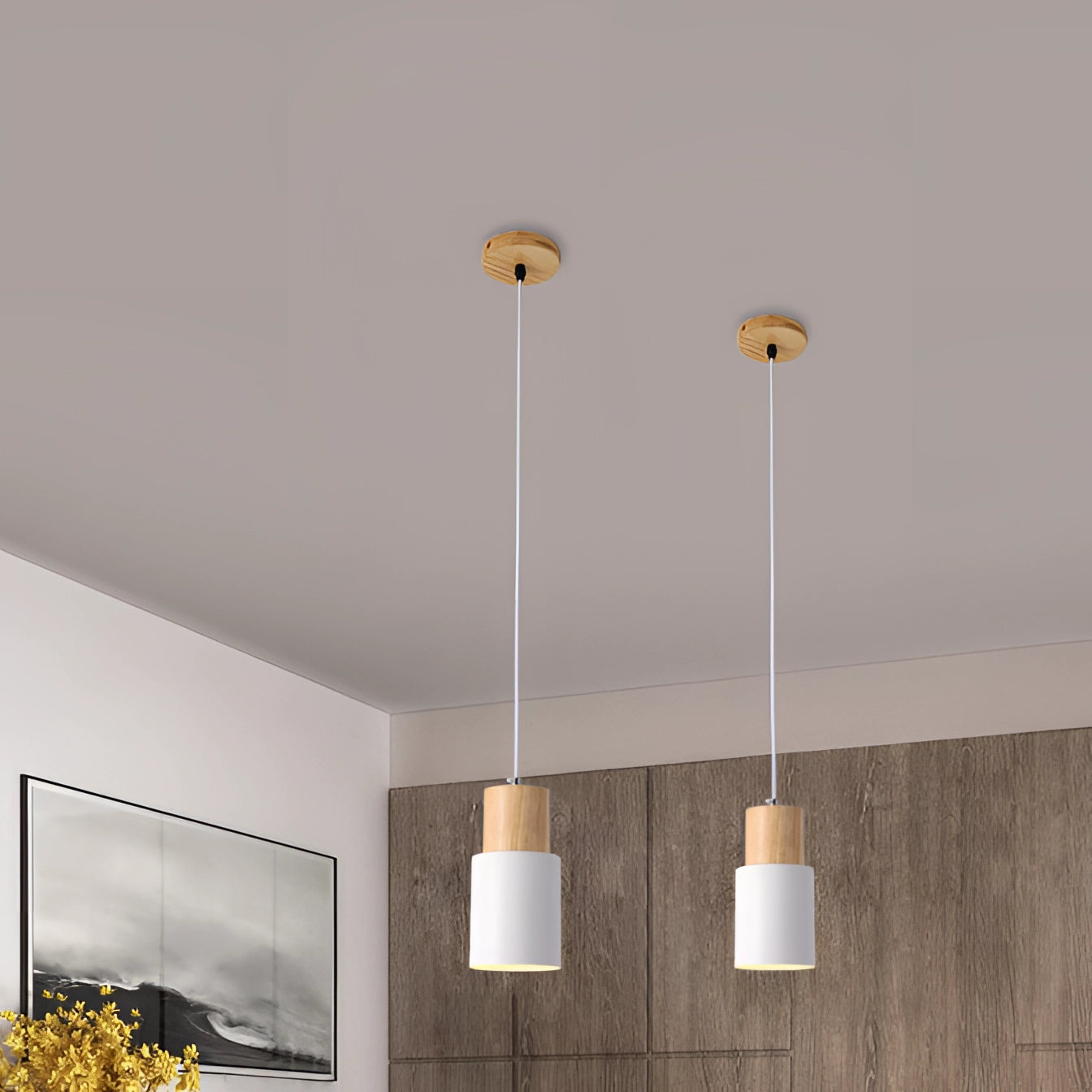 Nordic modern pendant light featuring a Scandinavian style with wood accents, suspended in a room with contemporary decor. The pendant light has an adjustable hanging length and casts a warm glow, complementing the minimalist surroundings that include a plant, picture frame, and neutral-toned walls.