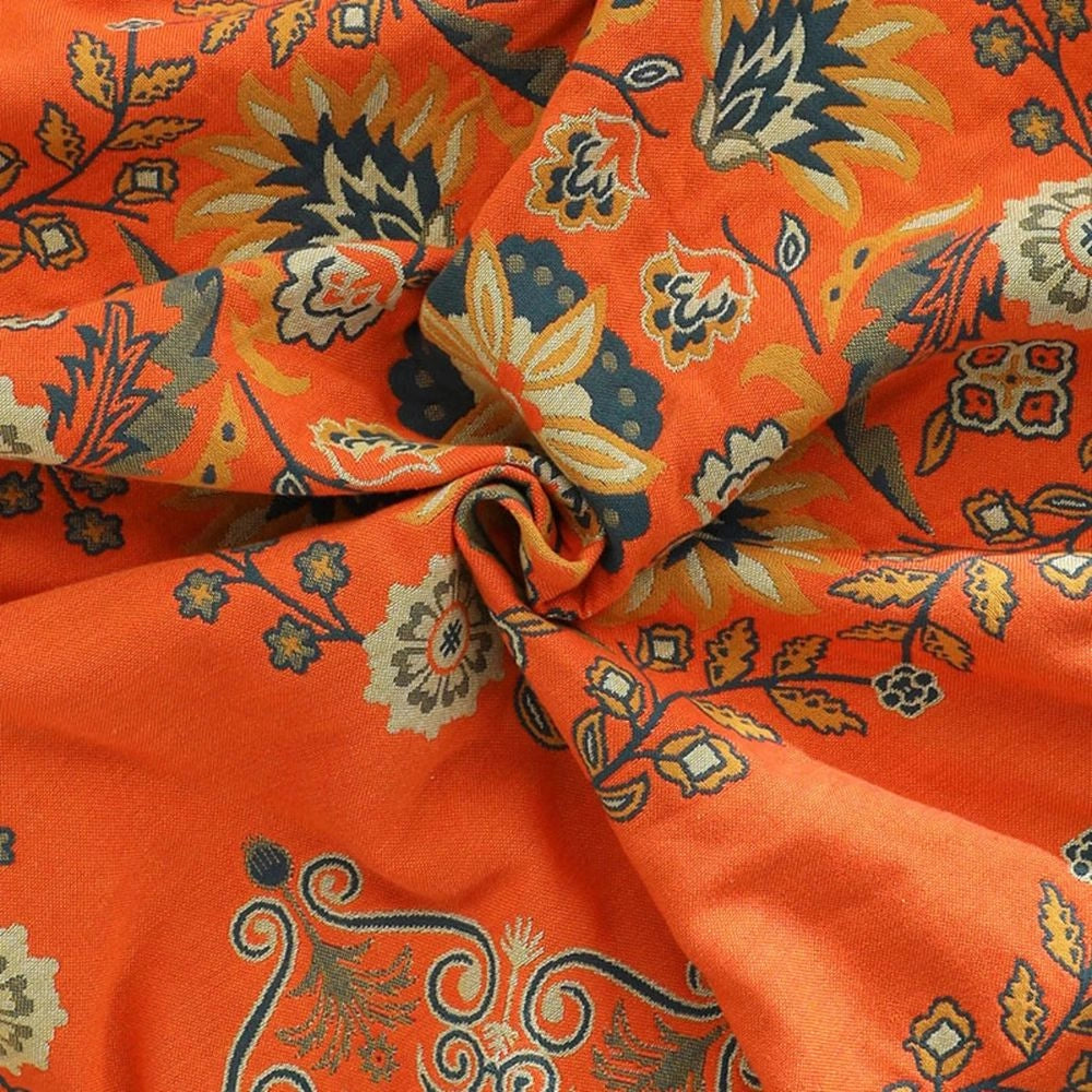 Orange Paisley Bohemian Tassel Throw Blanket made of luxurious cotton fabric featuring an intricate paisley pattern with tassel detailing, showcasing vibrant hues of orange and amber.