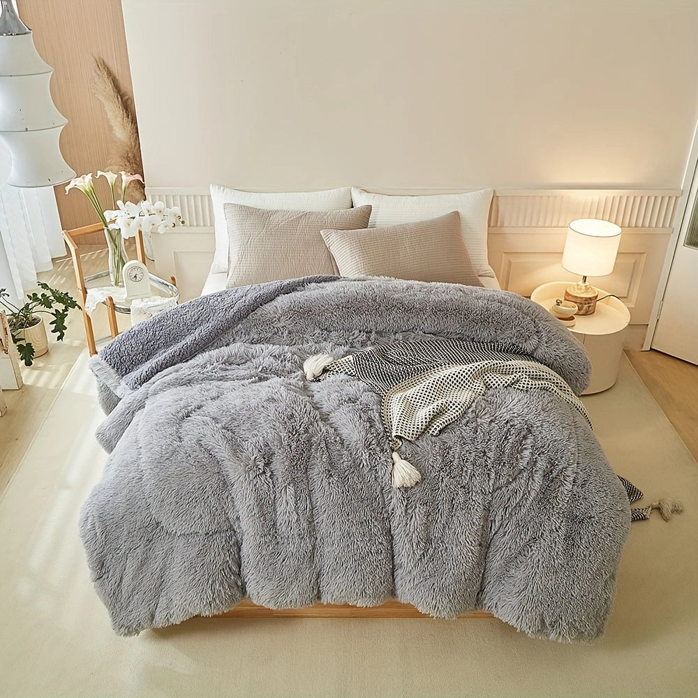 Gray pastel faux fur blanket draped over a bed in a cozy bedroom setting, featuring a wooden bed frame, complementing gray tones, and a warm, inviting atmosphere.