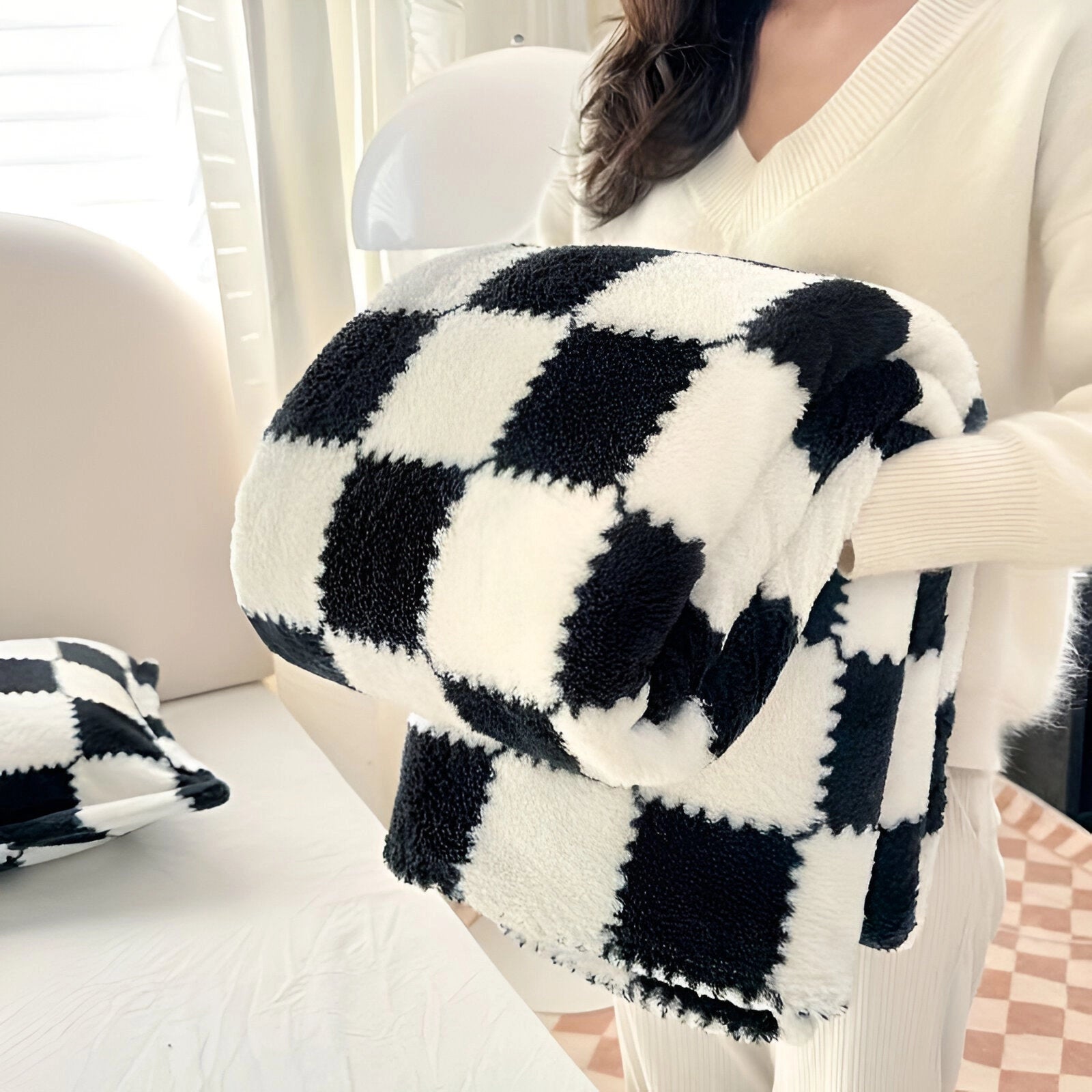 A black and white checkered fleece blanket measuring 200 x 230 cm, featuring a plush and soft texture perfect for cozy home decor.