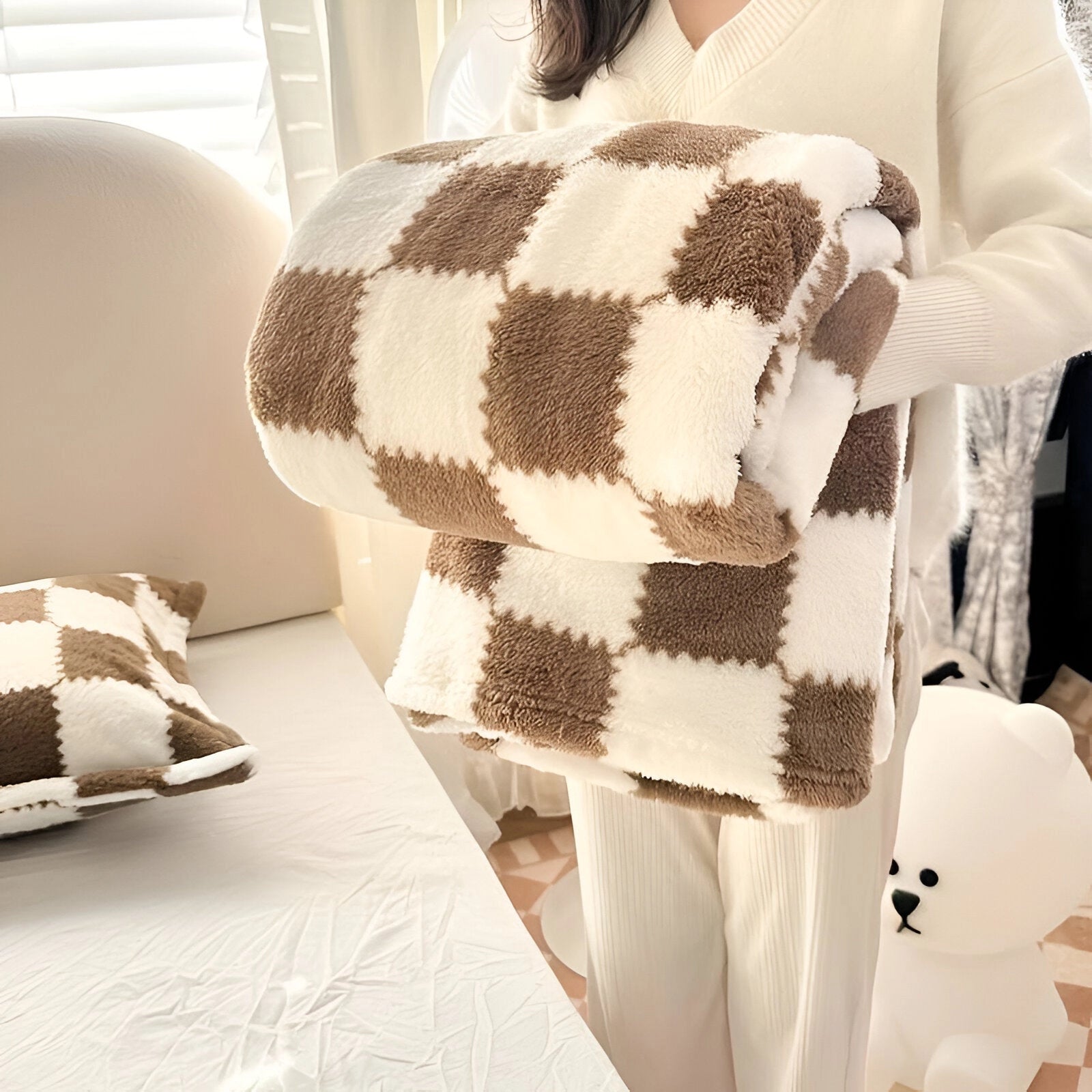 Pink and white checkered fleece blanket, soft and plush, laid out showing its cozy texture, in a Braun color variant with dimensions of 200 x 230 cm.