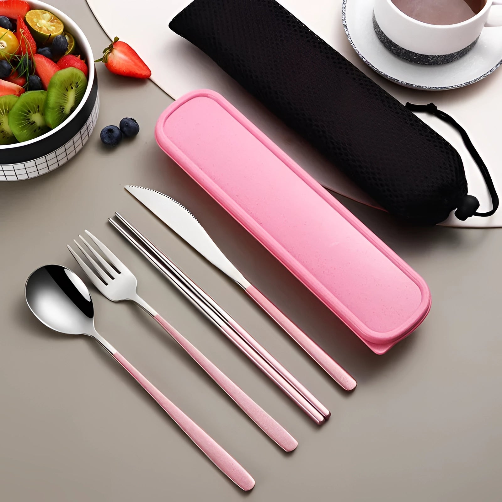 Portable eco-friendly cutlery set featuring rose-silver stainless steel utensils, including a fork, spoon, and knife, neatly arranged on a patterned napkin with a matching case, ideal for travel.