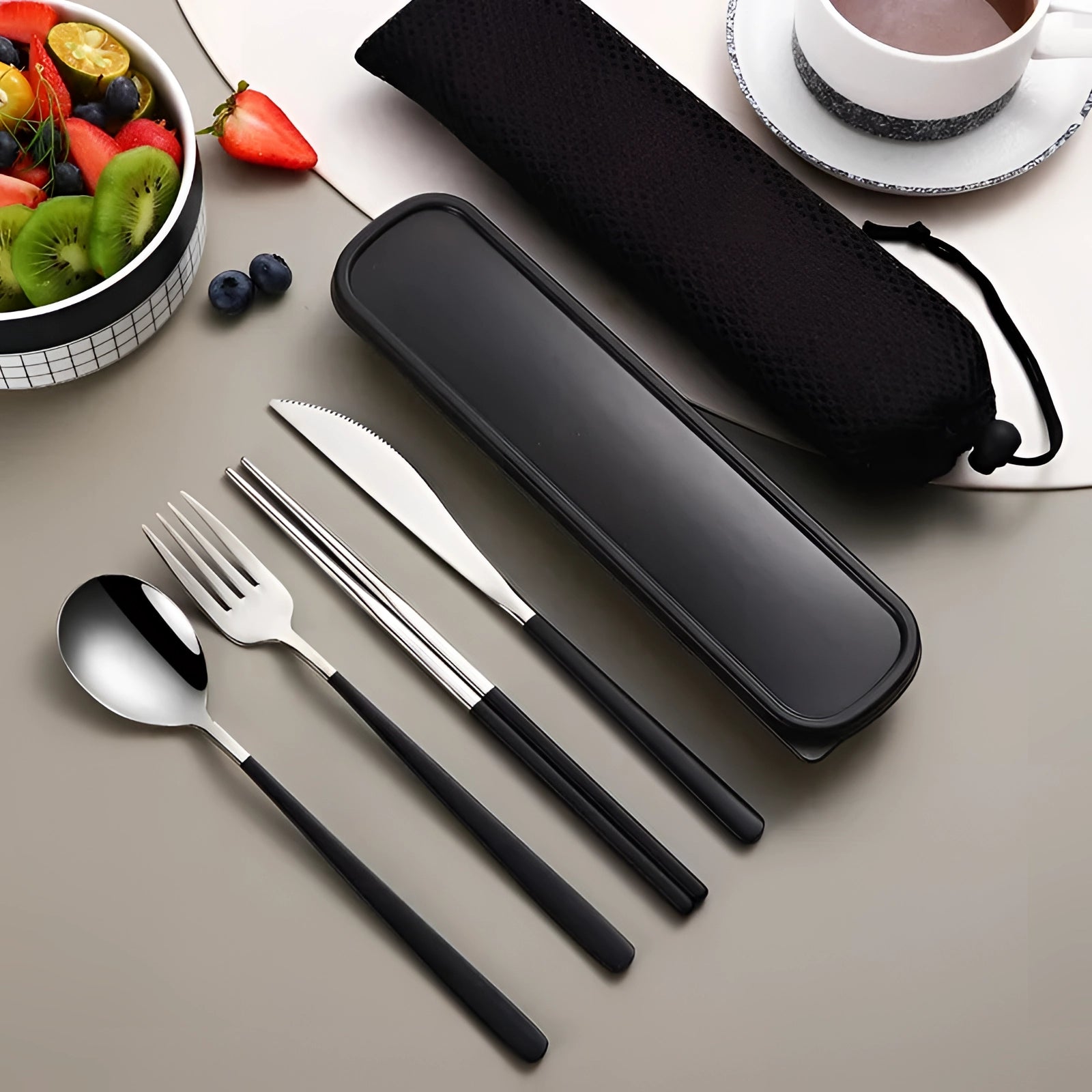 Portable eco-friendly stainless steel travel cutlery set with a sleek black-silver design, displayed with a matching rectangular case, alongside a plate and a napkin, suitable for on-the-go dining and sustainable living.