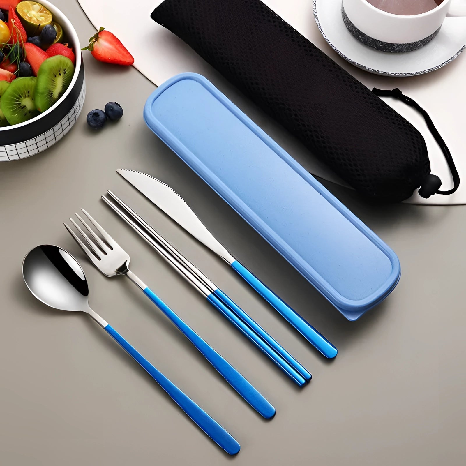 Portable eco-friendly stainless steel travel cutlery set in blue-silver, featuring a fork, knife, spoon, and chopsticks neatly arranged on a table with a blue rectangular carrying case.