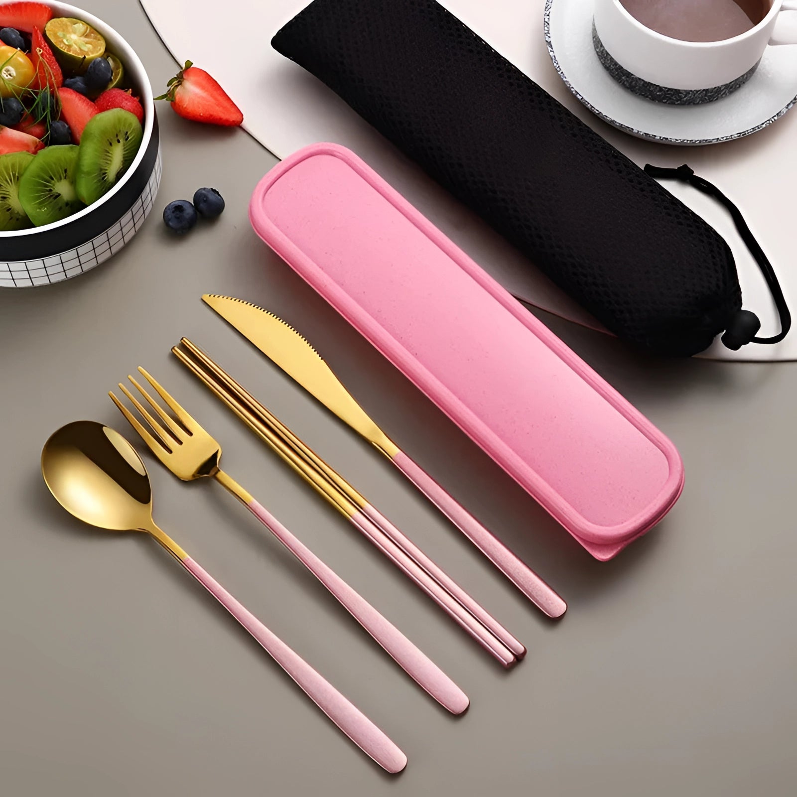 Portable eco-friendly stainless steel travel cutlery set in rose gold, displayed with a case, featuring a knife, fork, and spoon atop a table setting.