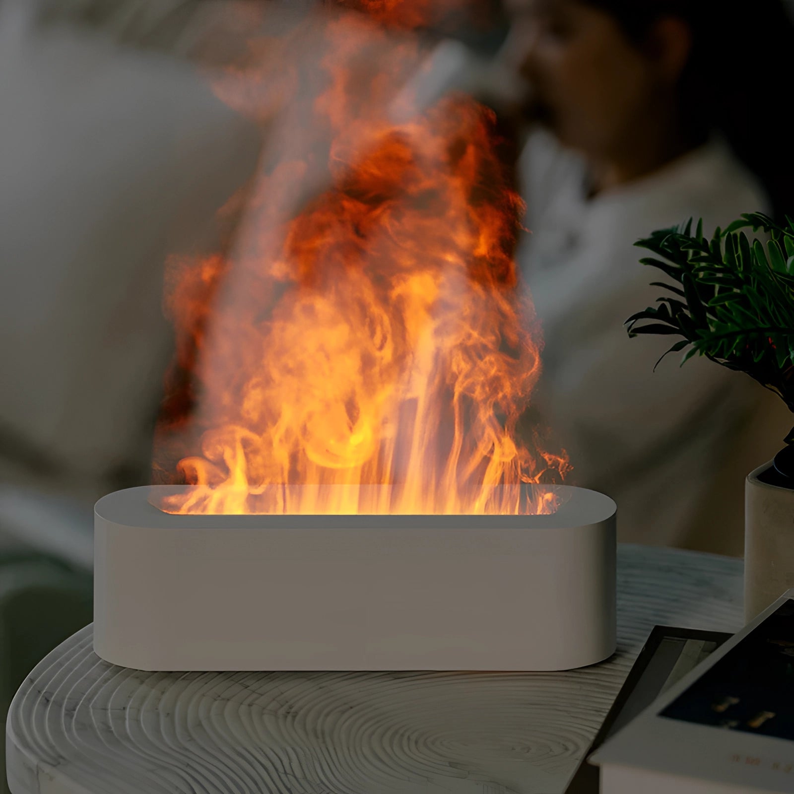 Portable USB flame diffuser and electric fireplace with realistic LED flames glowing in orange, creating a cozy ambiance reminiscent of a small fire.