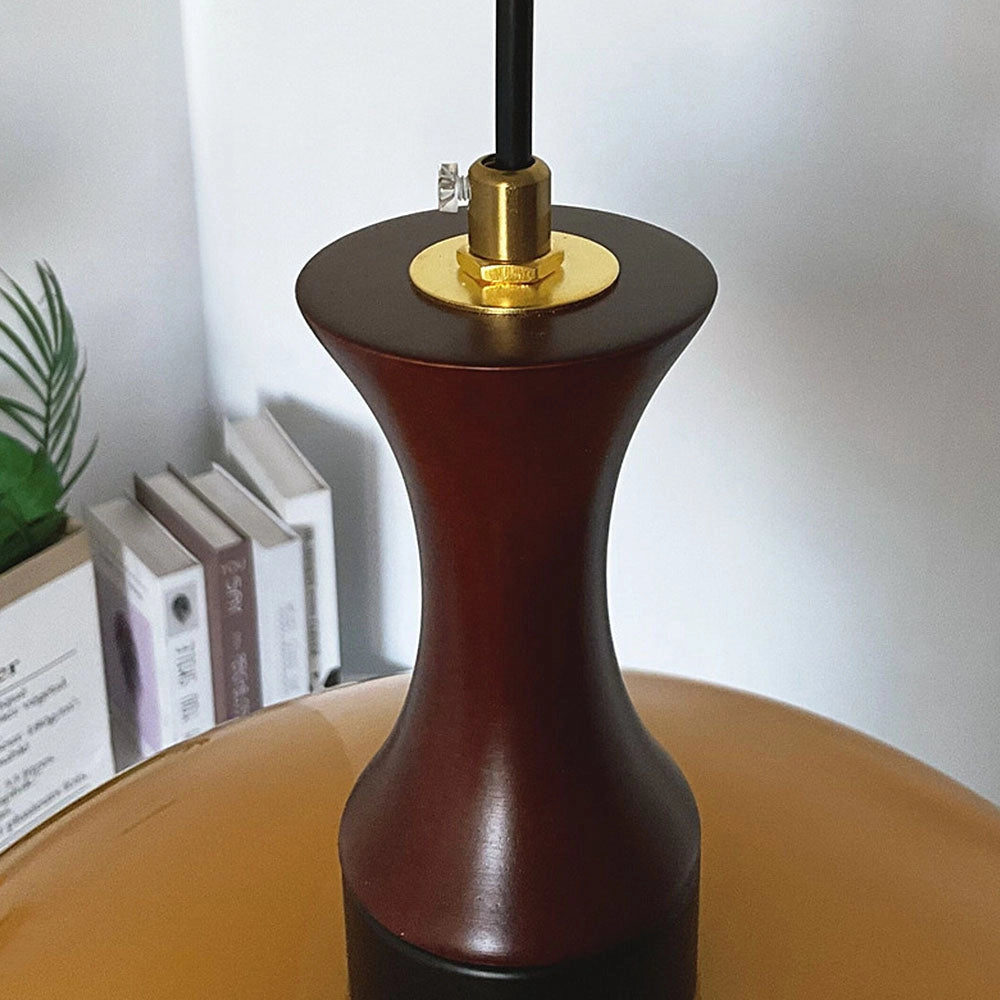 Retro Yellow Mid-Century Pendant Light hanging over a wooden table with a houseplant and decorative artifacts.