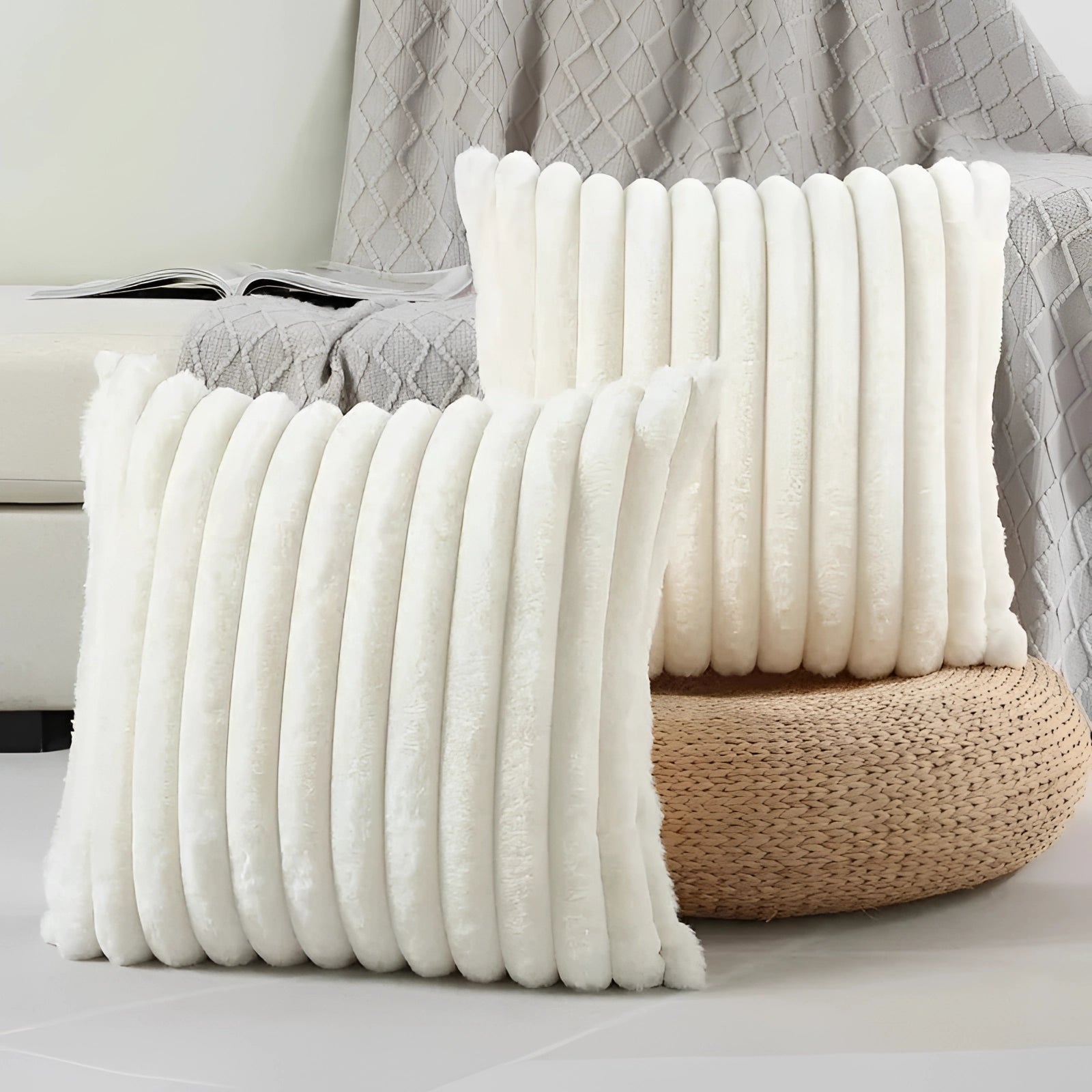 Elegant white ribbed throw pillows placed on a beige studio couch, enhancing modern decor with plush comfort.