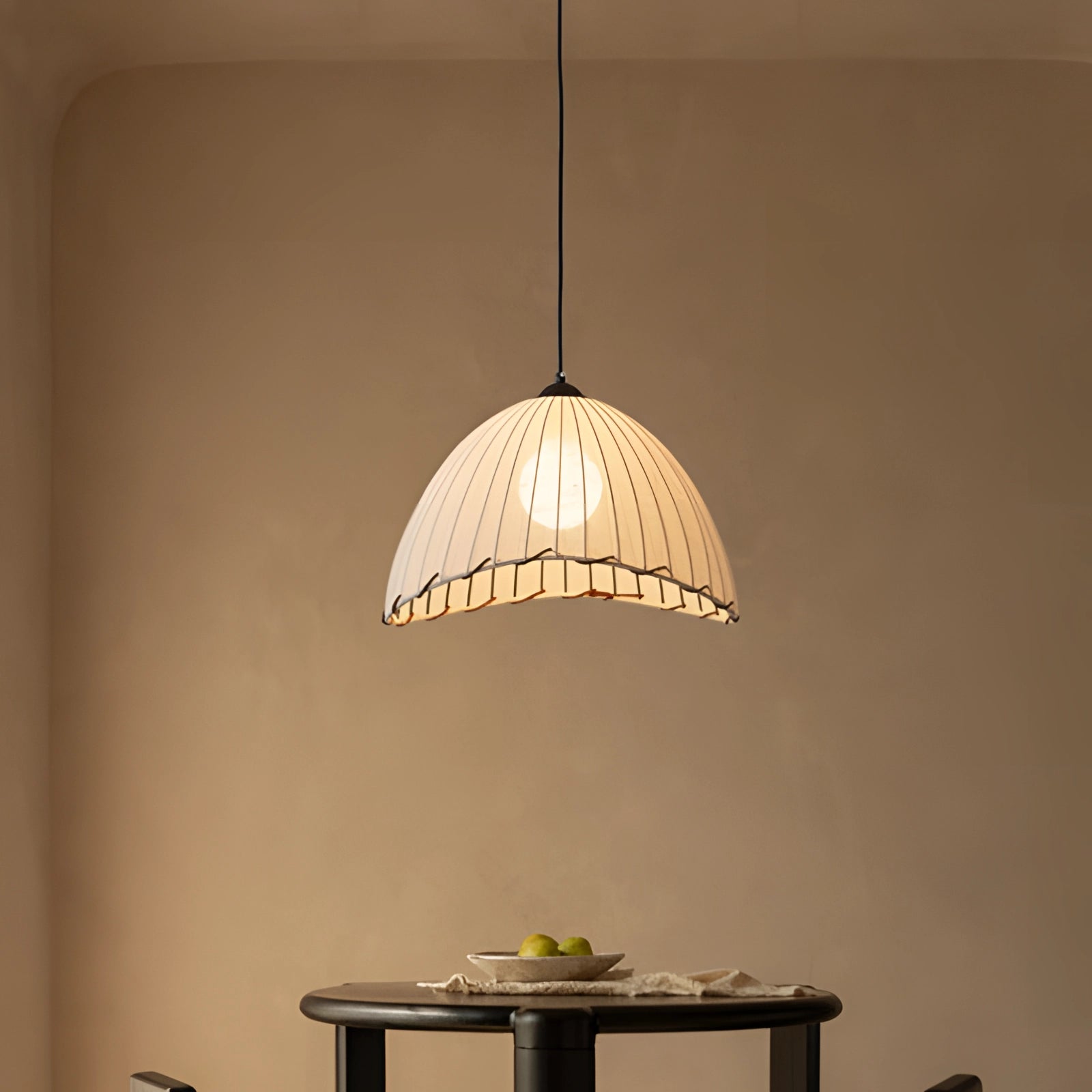 Scalloped LED pendant light with a gold interior, modern tiered chandelier hanging above a wooden table.