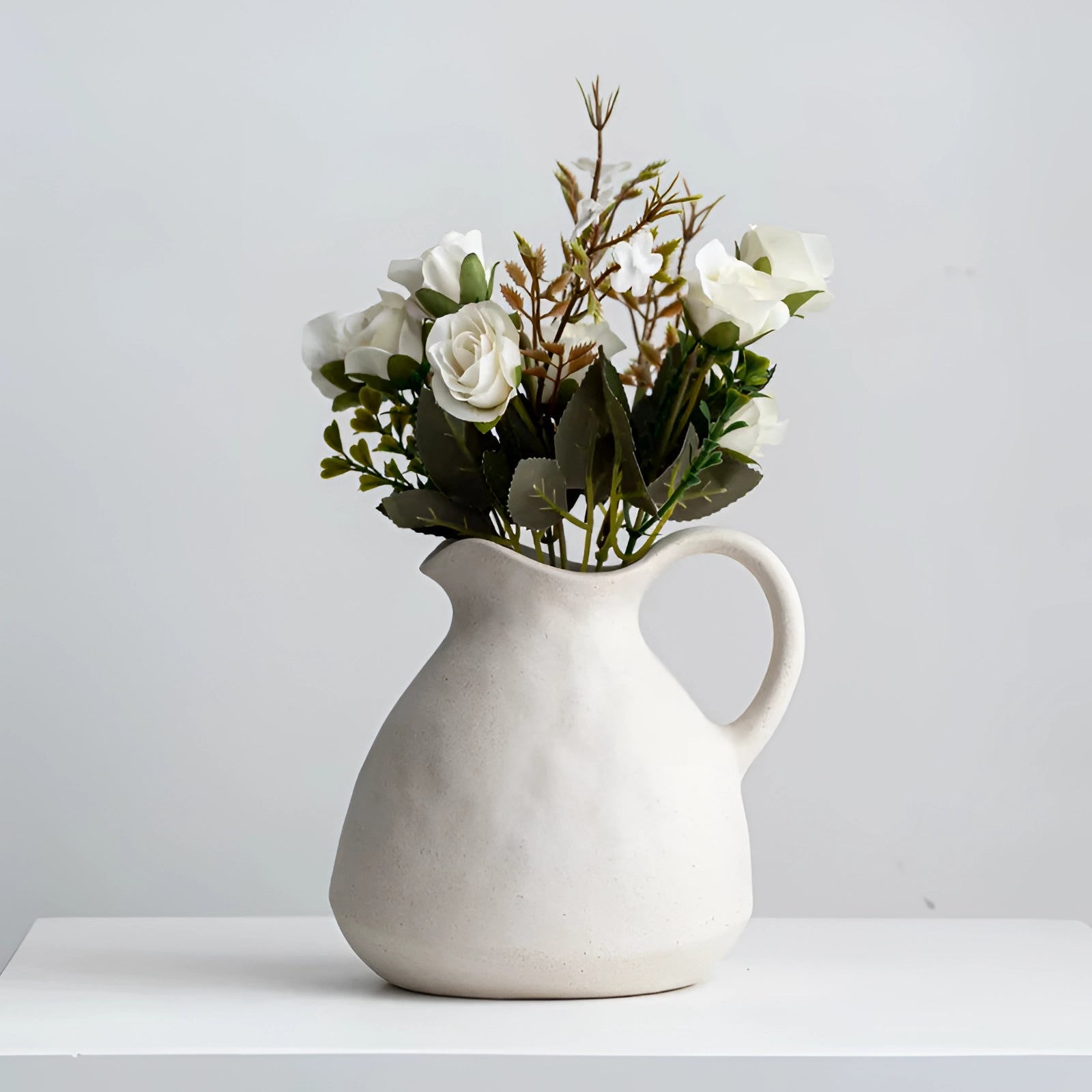 Elegant Scandinavian ceramic flower jug in minimalist white design, featuring a sleek vase shape suitable for decor, with a smooth porcelain finish perfect for displaying flowers or houseplants.