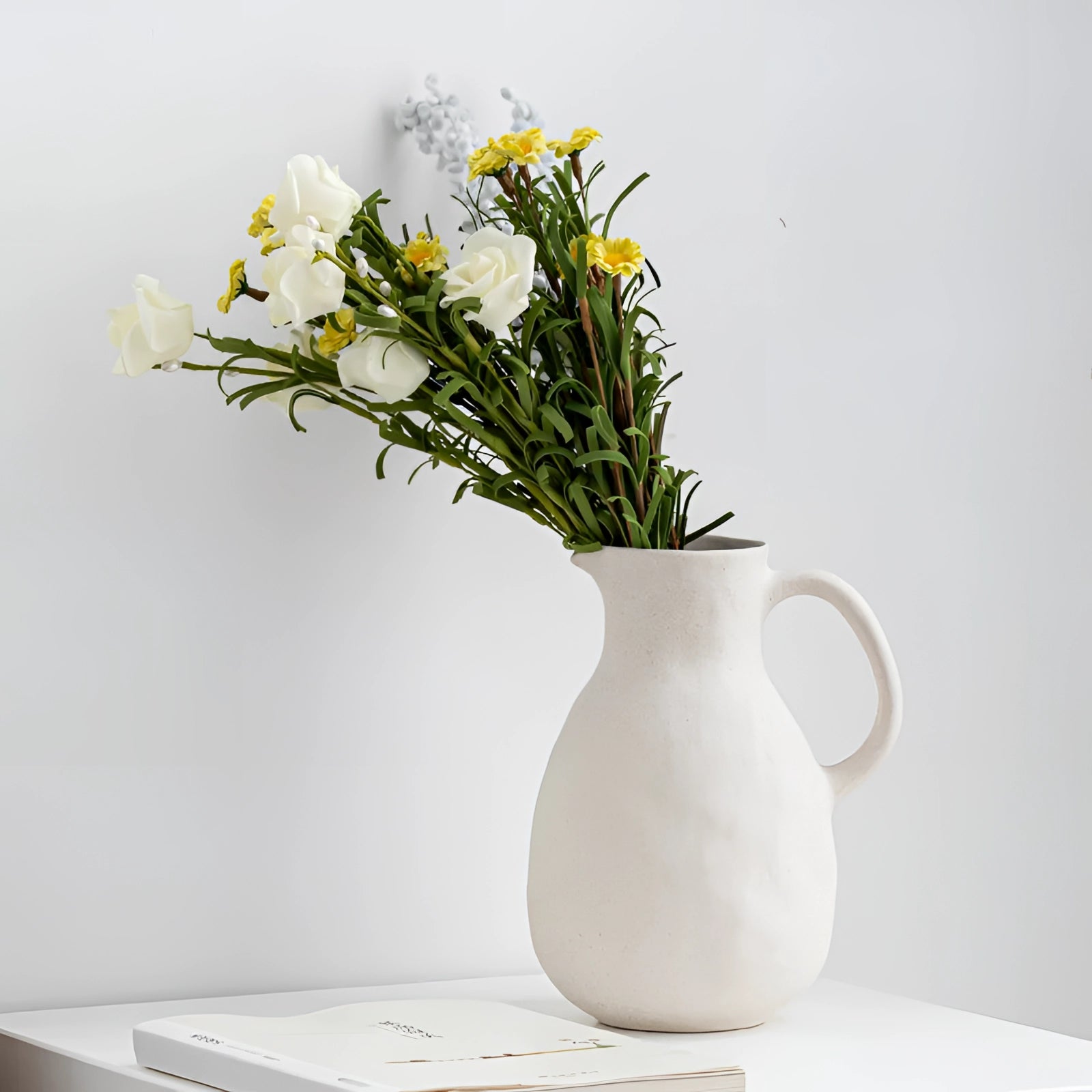 Minimalist white ceramic flower jug with a Scandinavian design, elegantly displaying a bouquet of flowers, perfect for home decor and flower arranging.