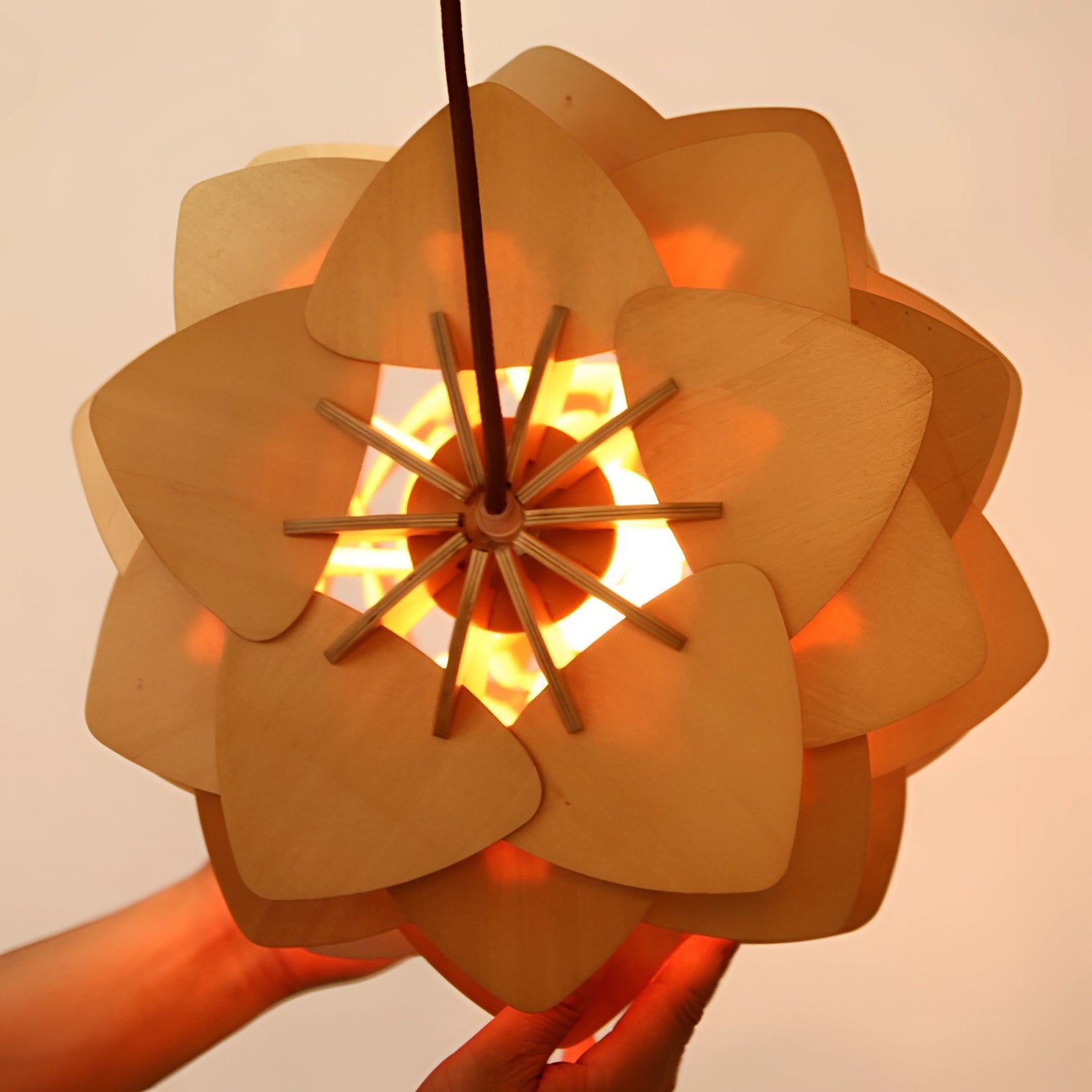 Scandinavian Pinecone Pendant Light with a modern organic design, featuring overlapping orange petal-like segments arranged symmetrically, creating an artistic and nature-inspired ceiling lamp.